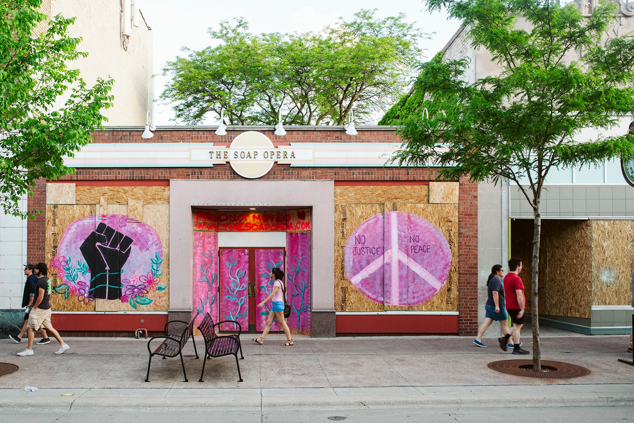 Artwork is displayed on boarded up store windows on State Street in downtown Madison