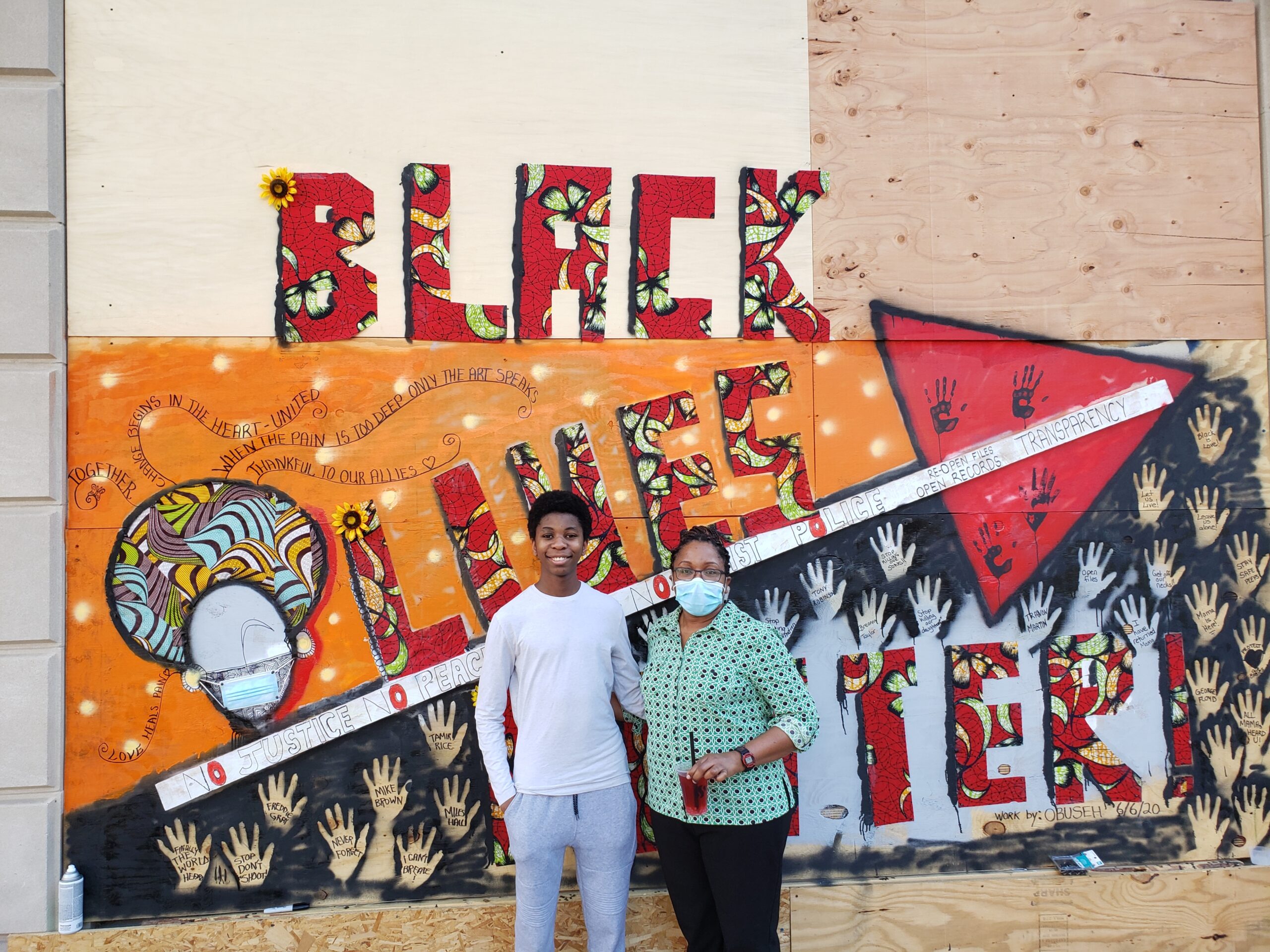 Batenga Obuseh and her 15-year-old son, Kiyem Obuseh, work on one of the State Street murals covering the Overture Center for the Arts.