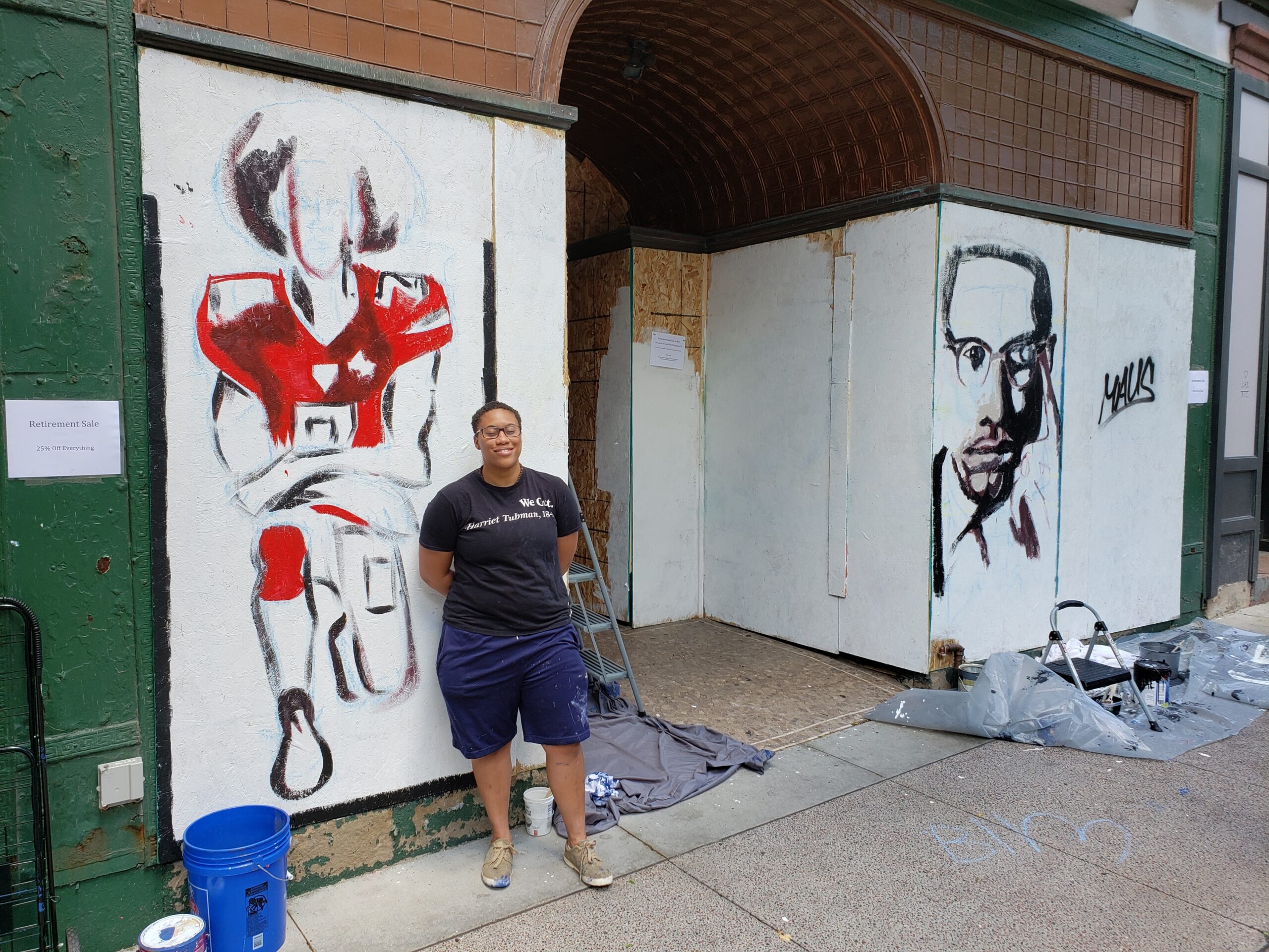 Madison artist Simone Lawrence works on of her murals of Malcolm X and Colin Kaepernick. Shawn Johnson / WPR