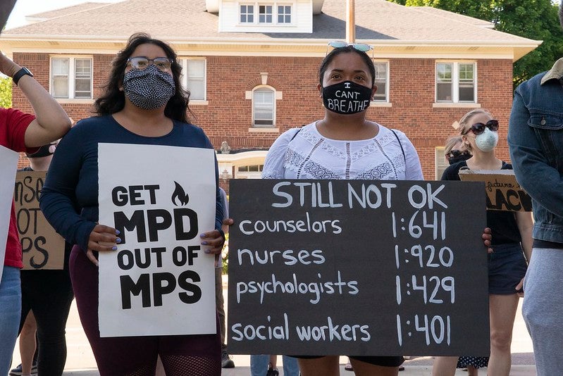 Protesters holding signs that say "Get MPD Out of MPS."