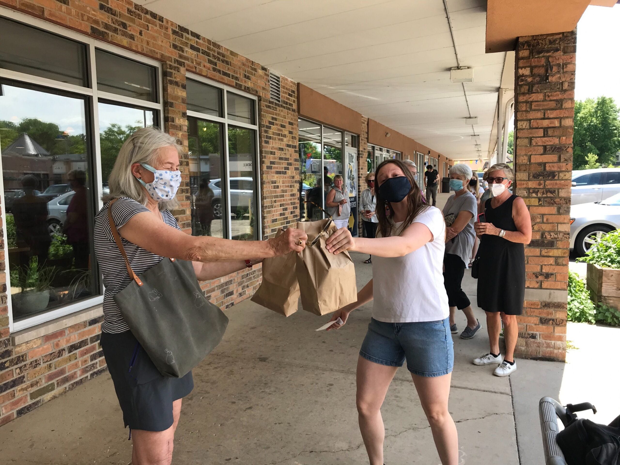 Allyson Deets from Manna Cafe hands takeout food to customer Paula Kraemer in this June 19, 2020 photo.