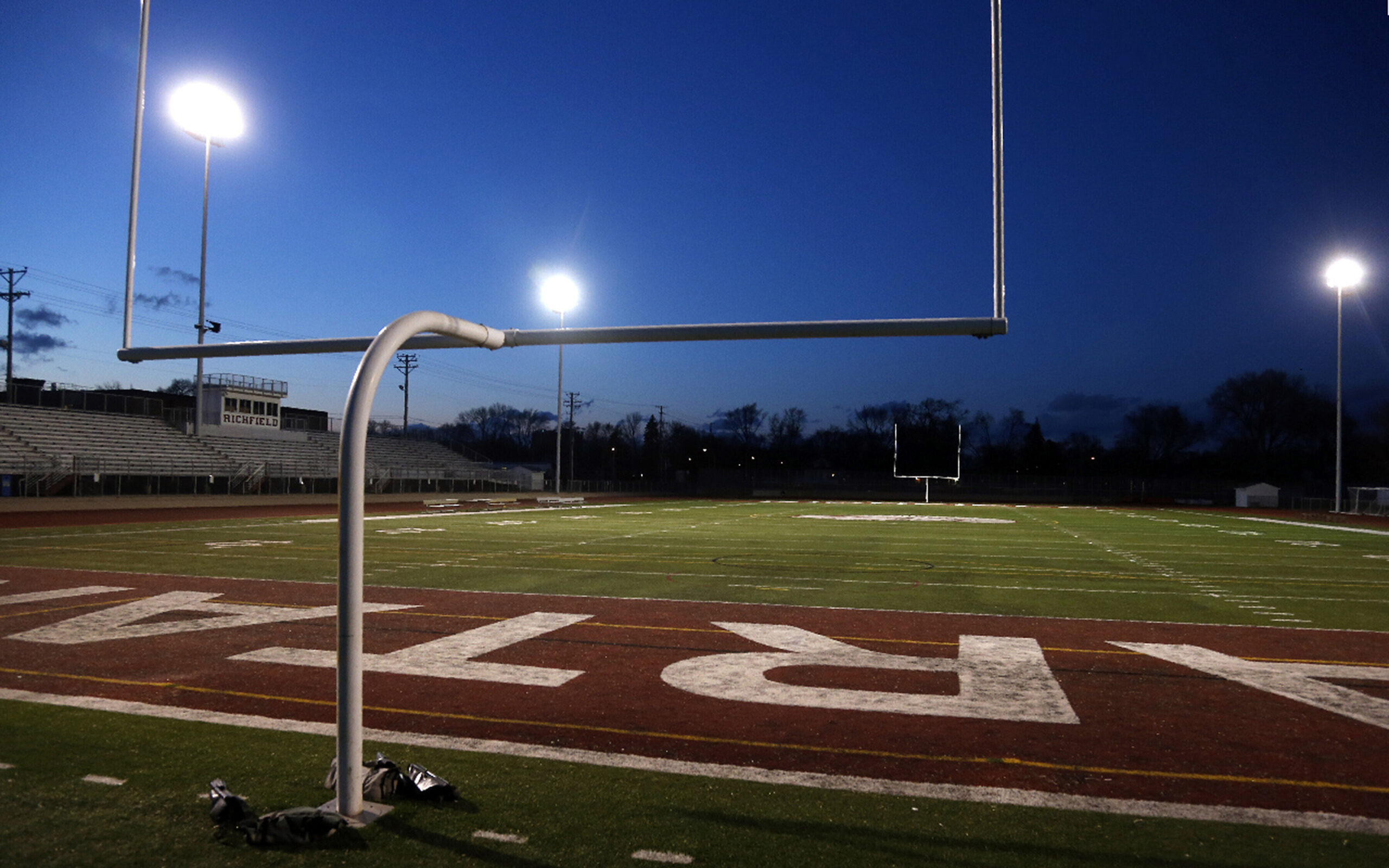The lights shine on an empty football stadium