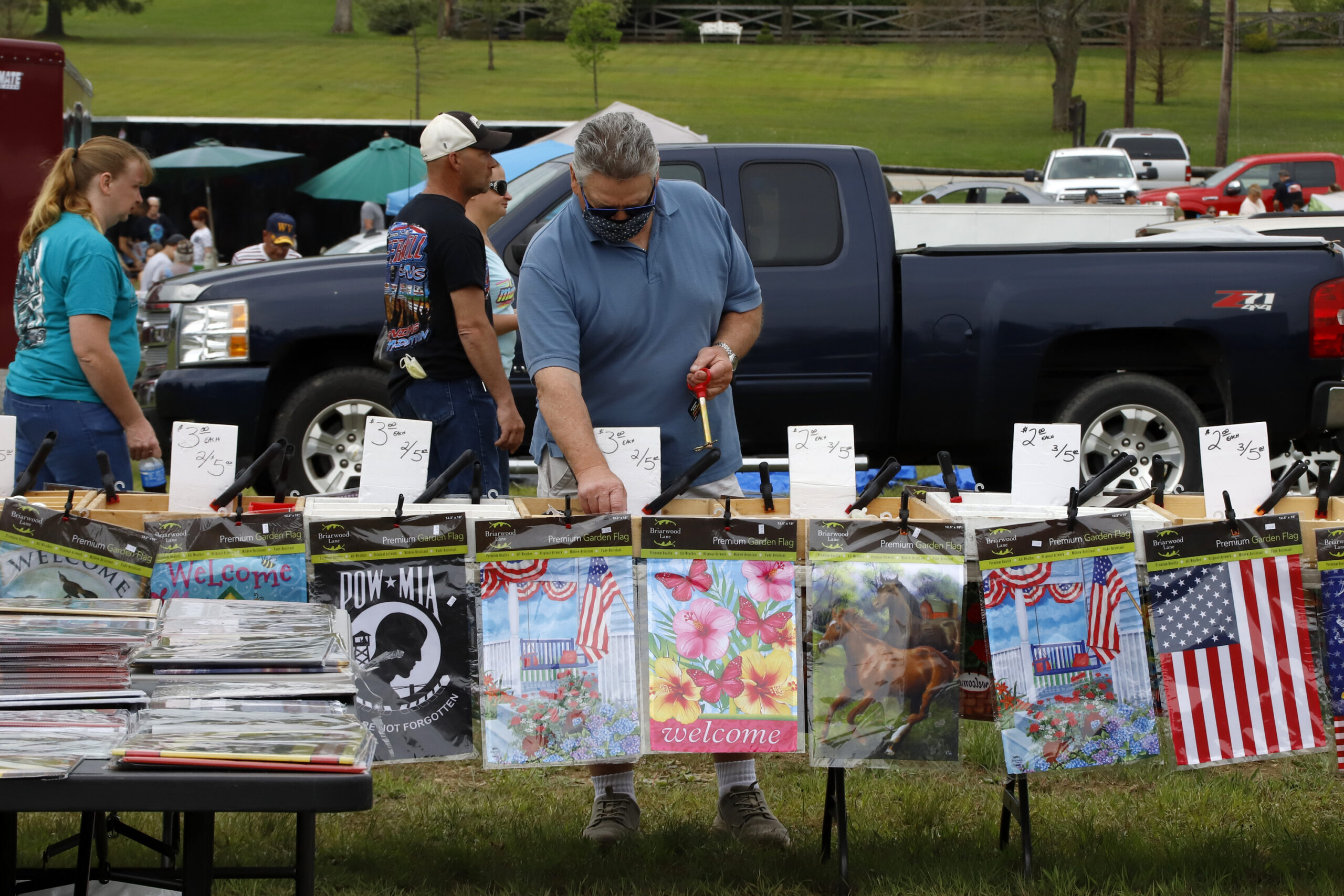 A man looks at items on a vendor's table at a flea market in Farmington, Pa.