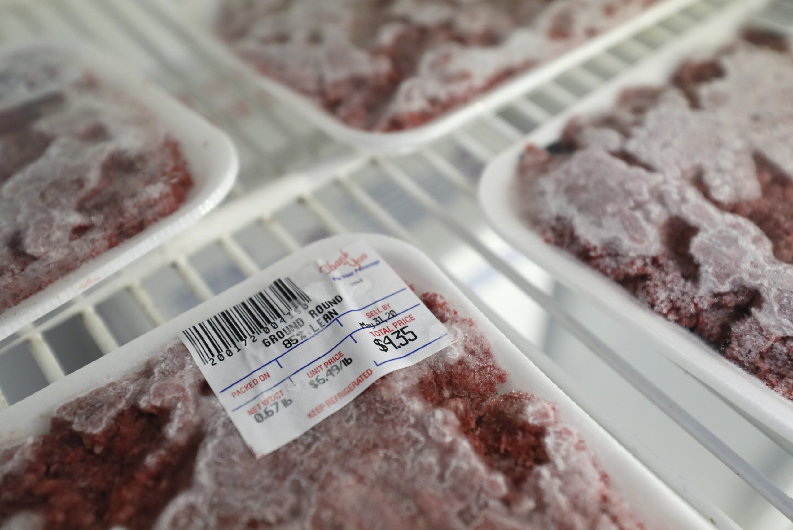 Packages of meat sit in a cooler at a local super market