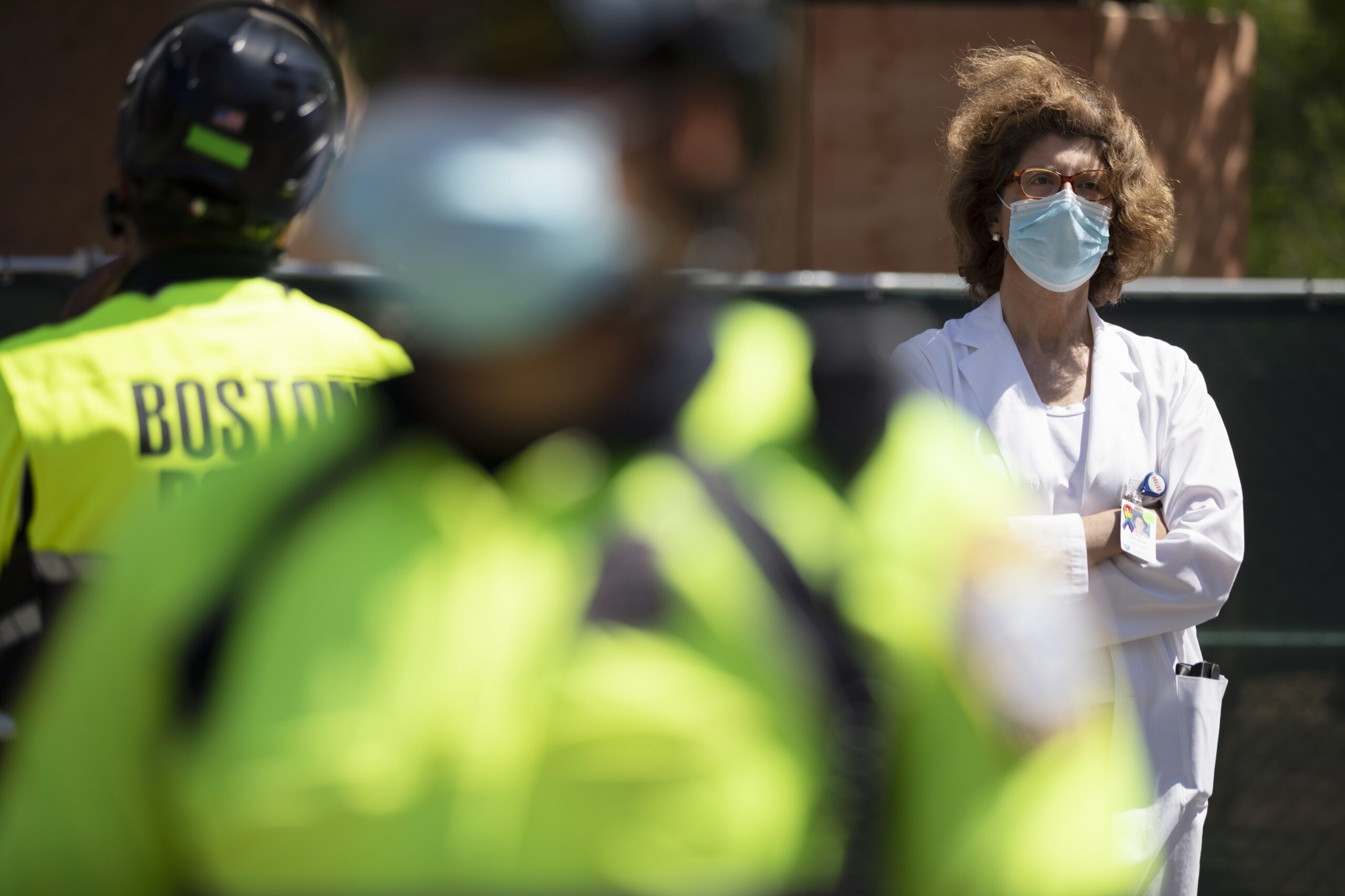 A doctor from Massachusetts General Hospital stands in counter-protest across the street from a demonstration calling for the lifting of all government restrictions related to concern about the spread of COVID-19.
