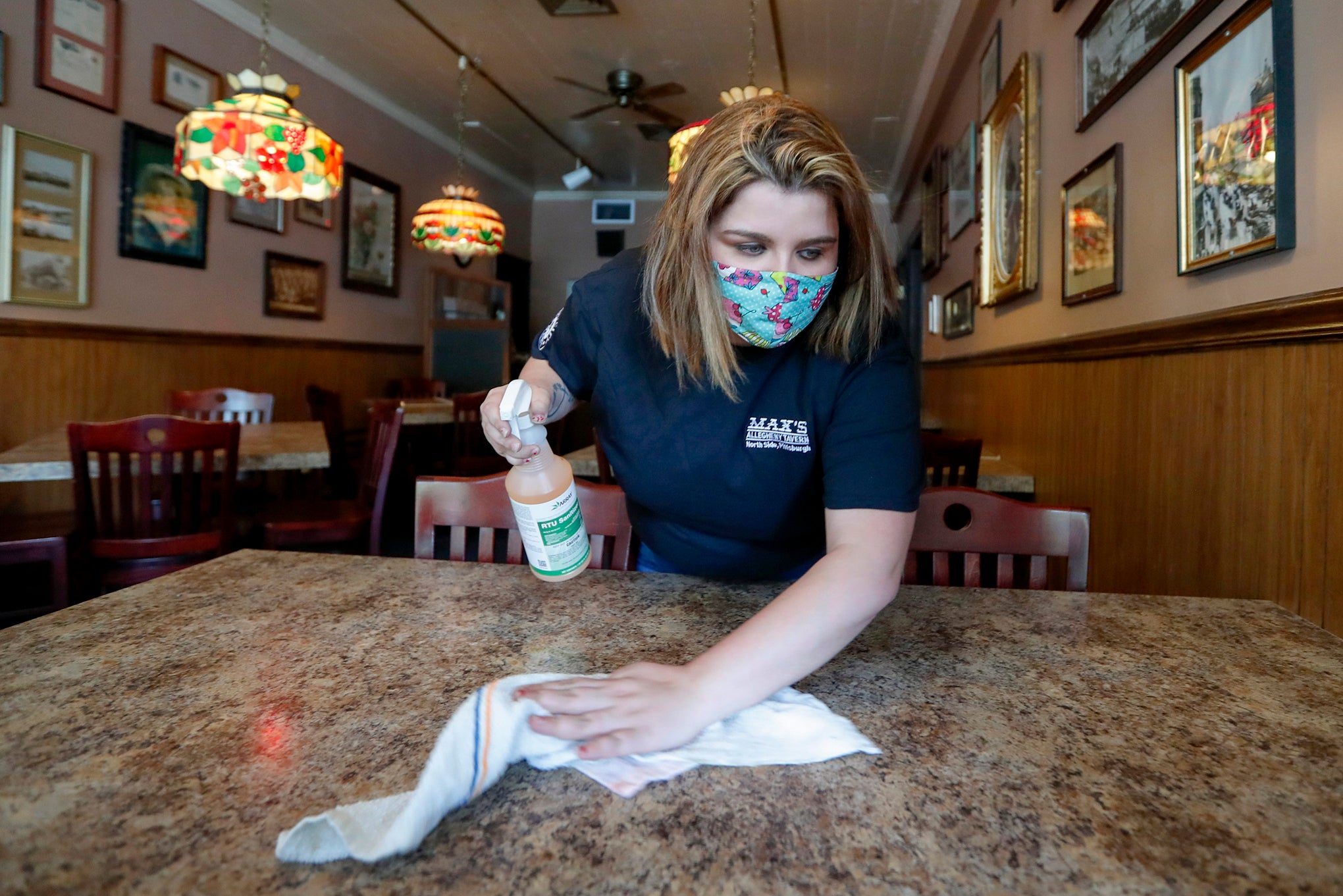 Sara Kennely, cleans one of the dining tables at Max's Allegheny Tavern