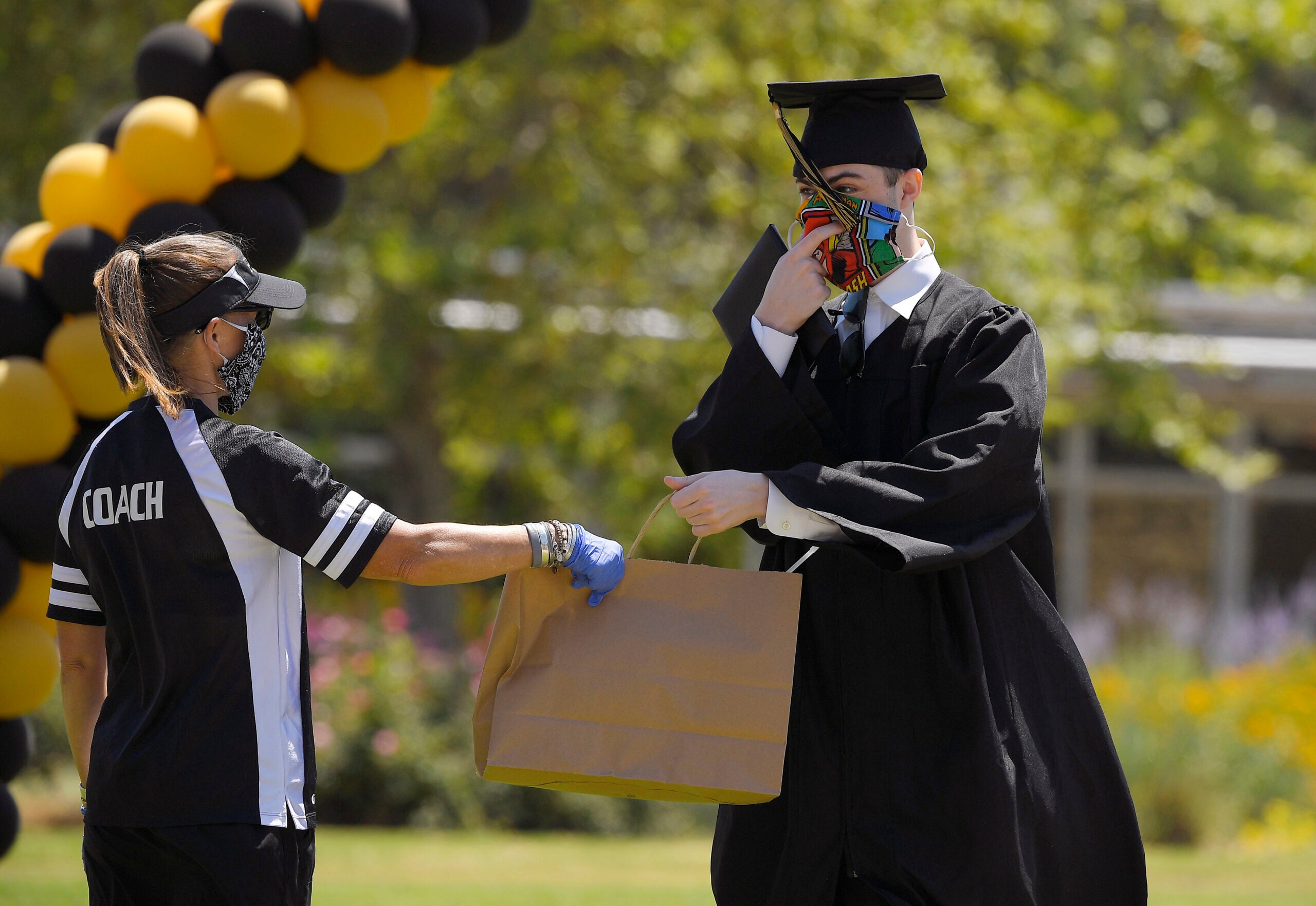 A graduate accepts a bag of gifts during graduation ceremonies.