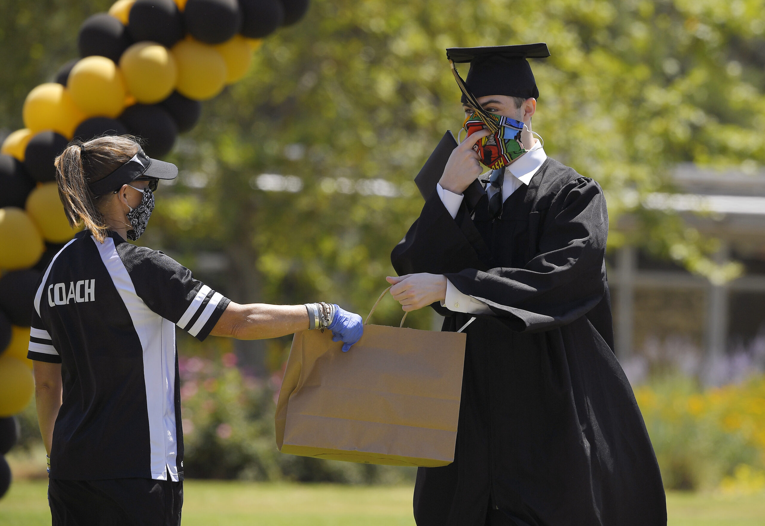 A graduate accepts a bag of gifts during graduation ceremonies.
