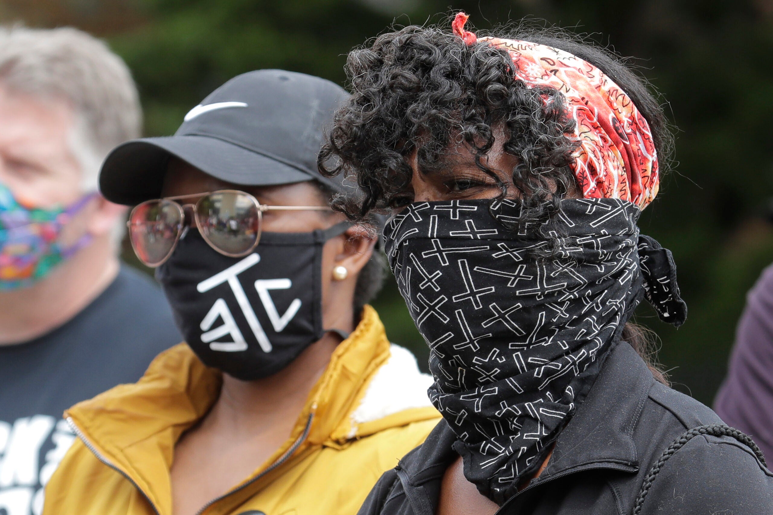 Protesters wear masks to help prevent the spread of the coronavirus, Friday in Tacoma, Wash.,