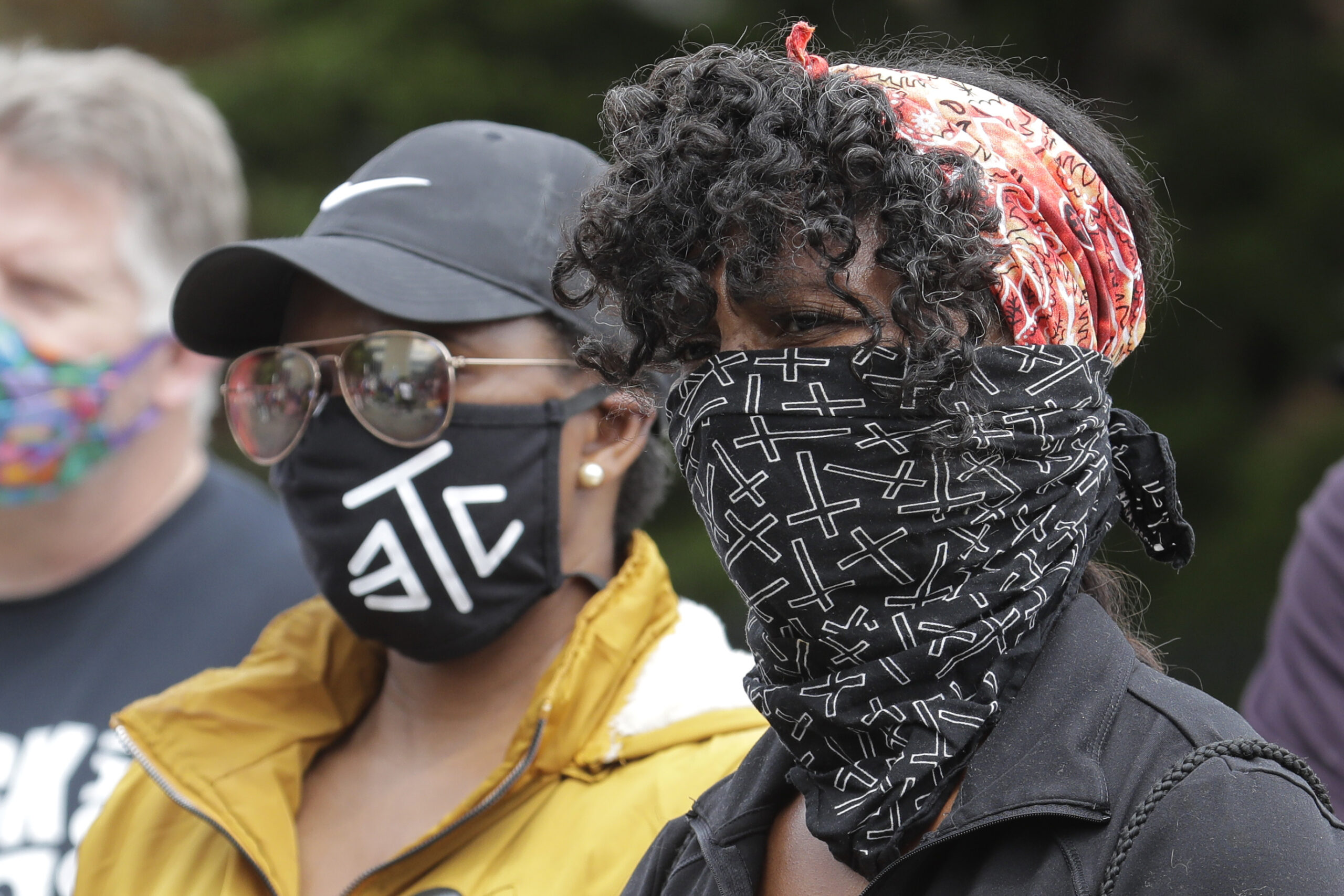 Protesters wear masks to help prevent the spread of the coronavirus, Friday in Tacoma, Wash.,