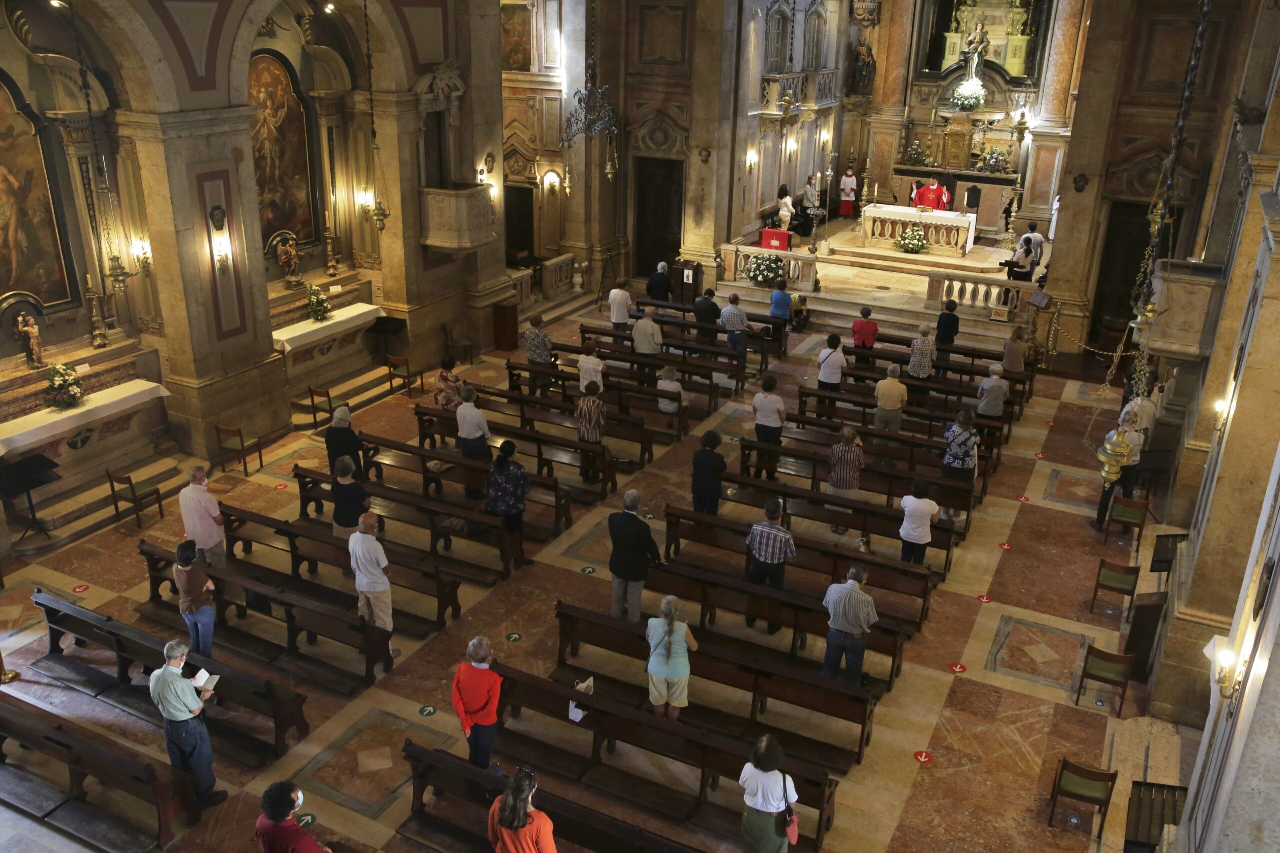 parishioners attend mass with significant space between them