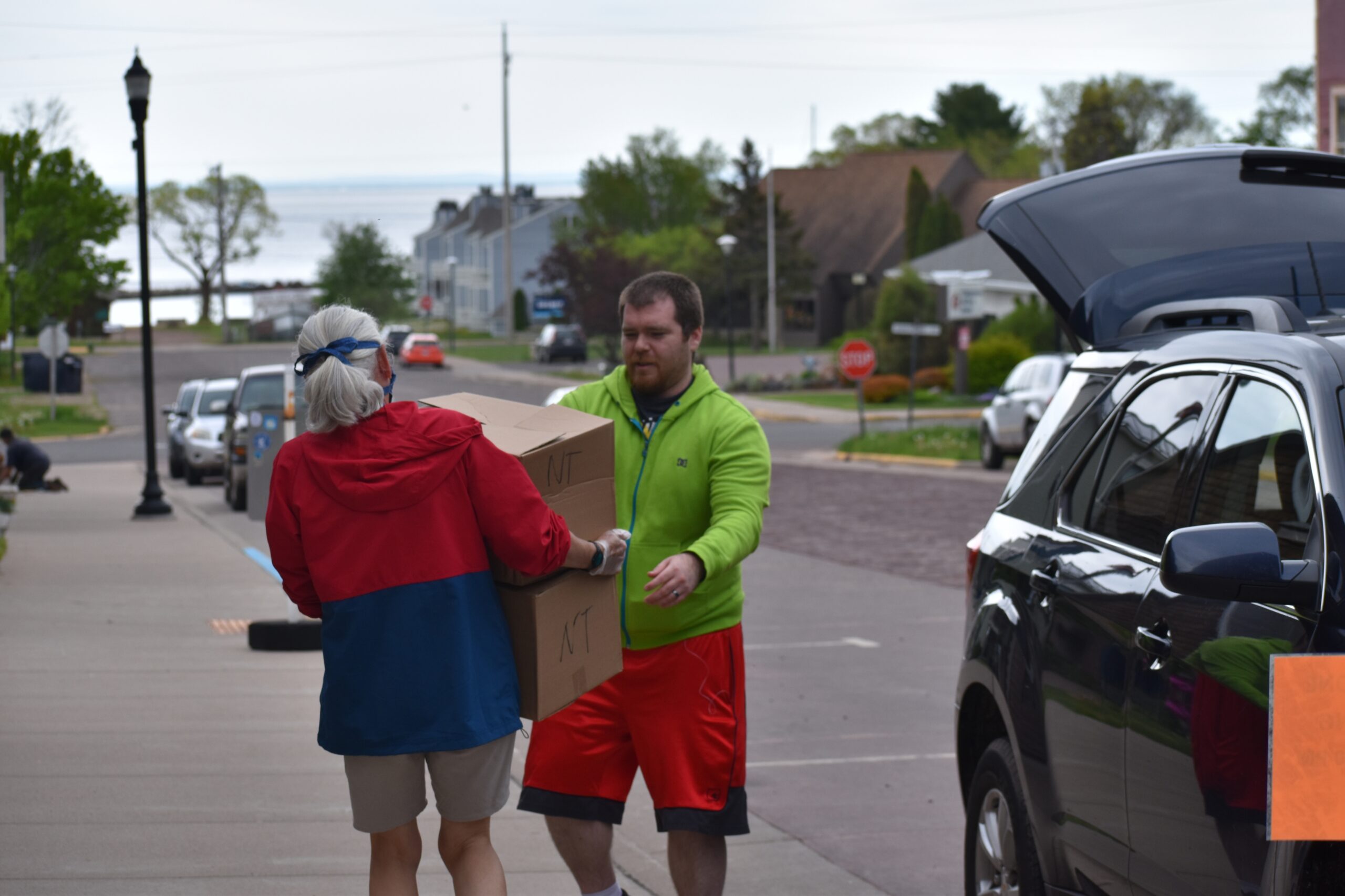 Volunteer Lisa Luttinen helps bring food boxes to Charles DeFoe