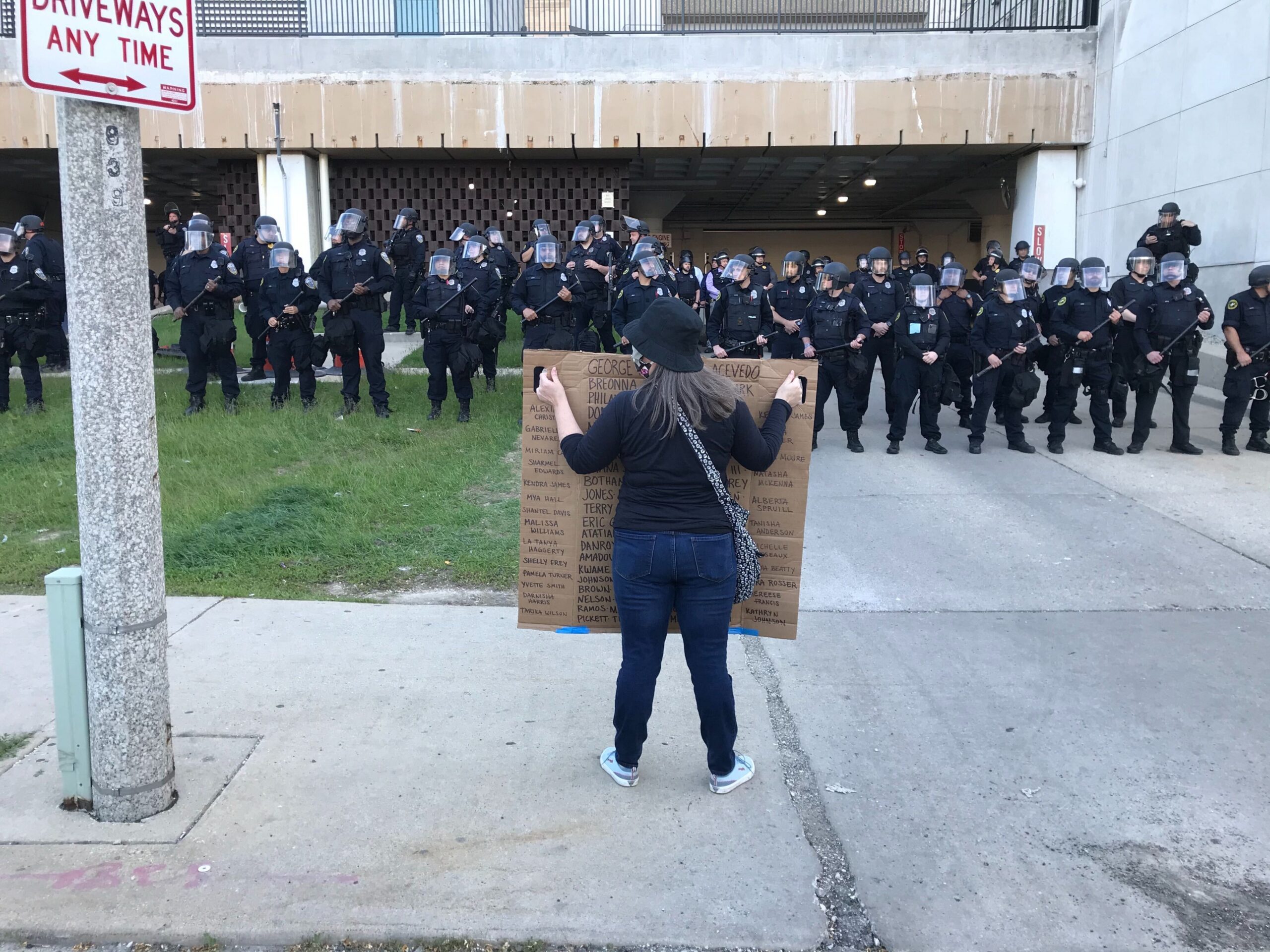 A protester holds a sign up to law enforcement gathered outside the city of Milwaukee's Municipal Court building on Sunday evening