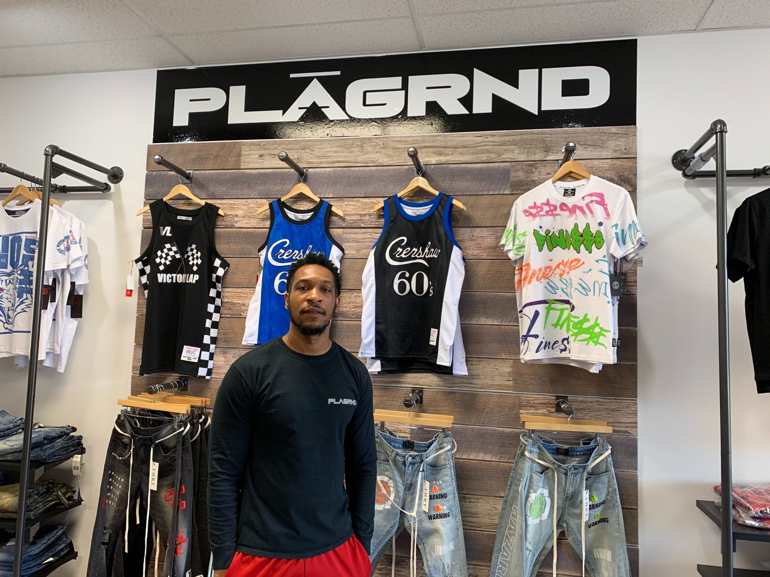 Synika Kirk poses PLAGRND, his clothing store in Green Bay
