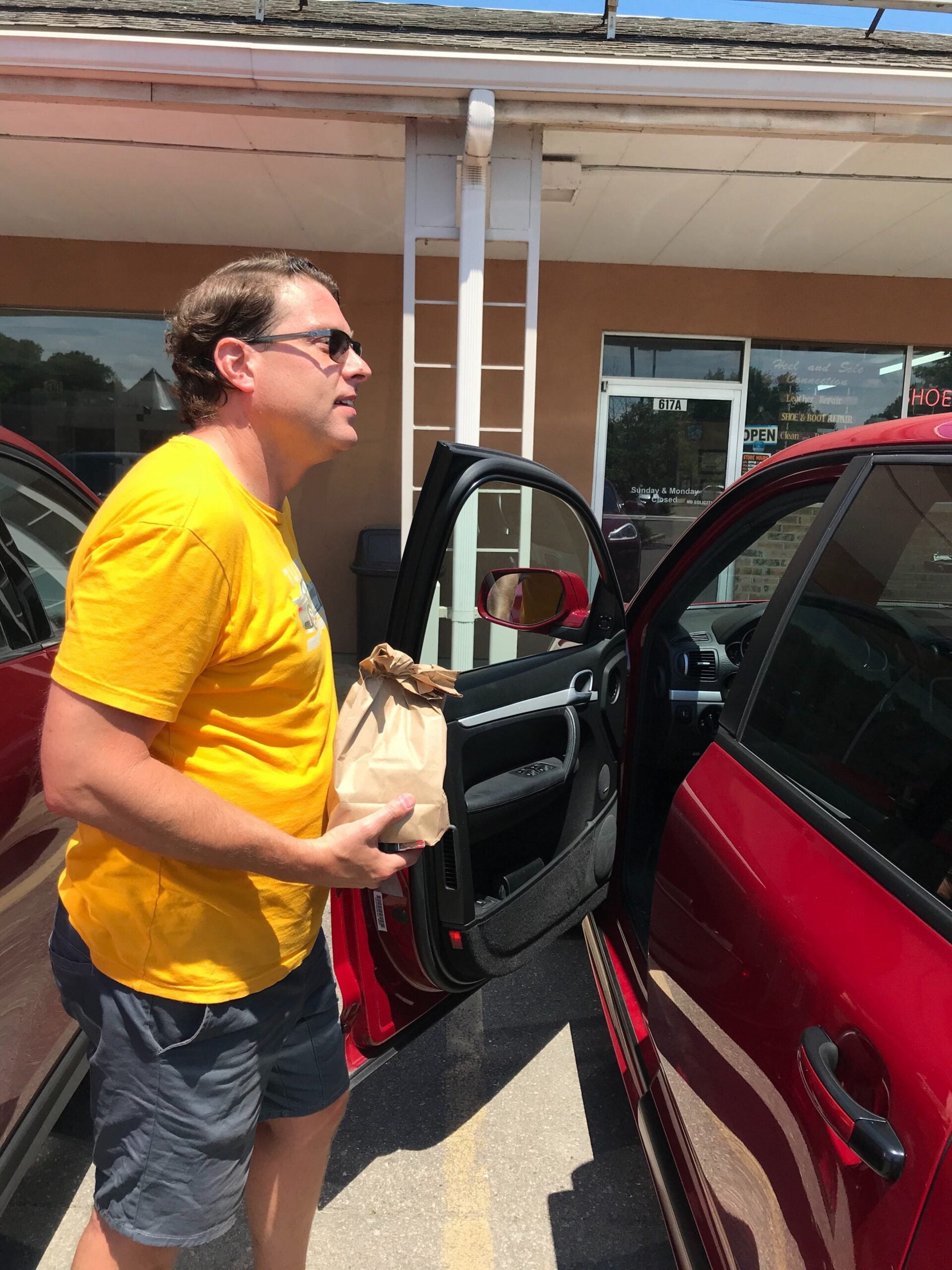 Ryan Braithwaite holds carryout food from Manna Cafe.