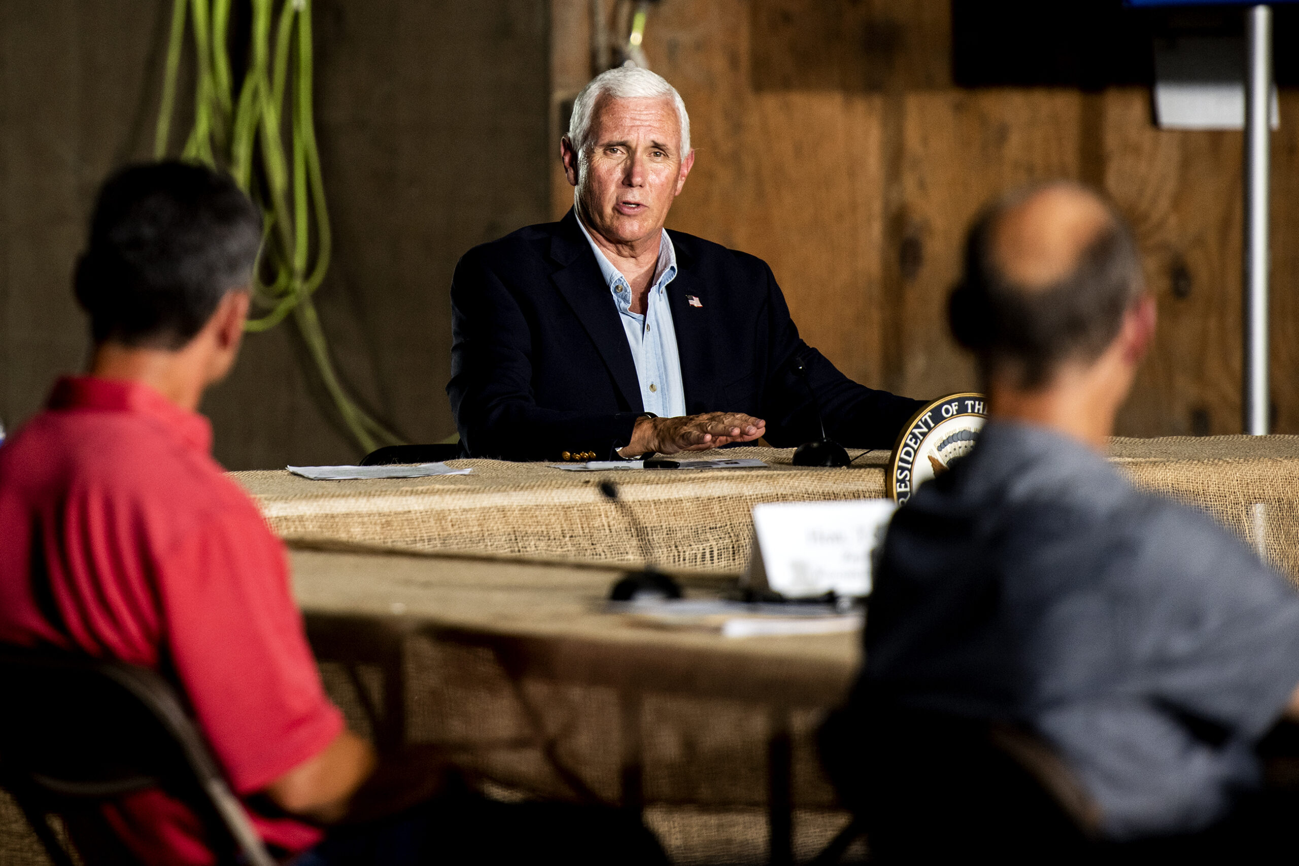 Vice President Mike Pence looks toward people at a round table