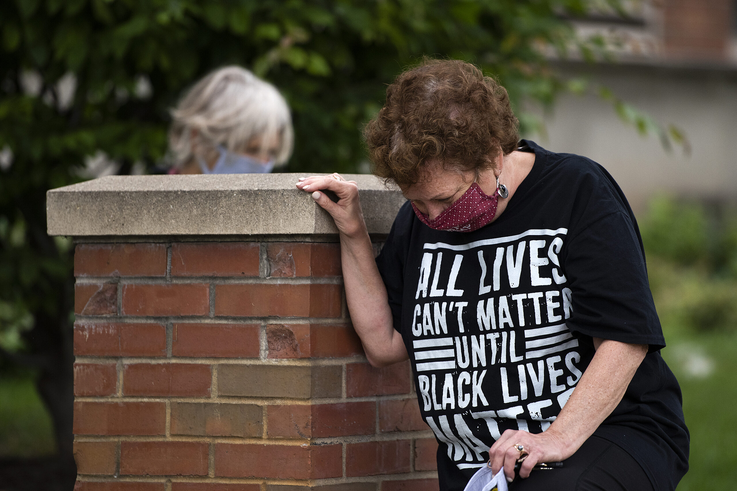 A woman kneels while wearing a shirt that says 