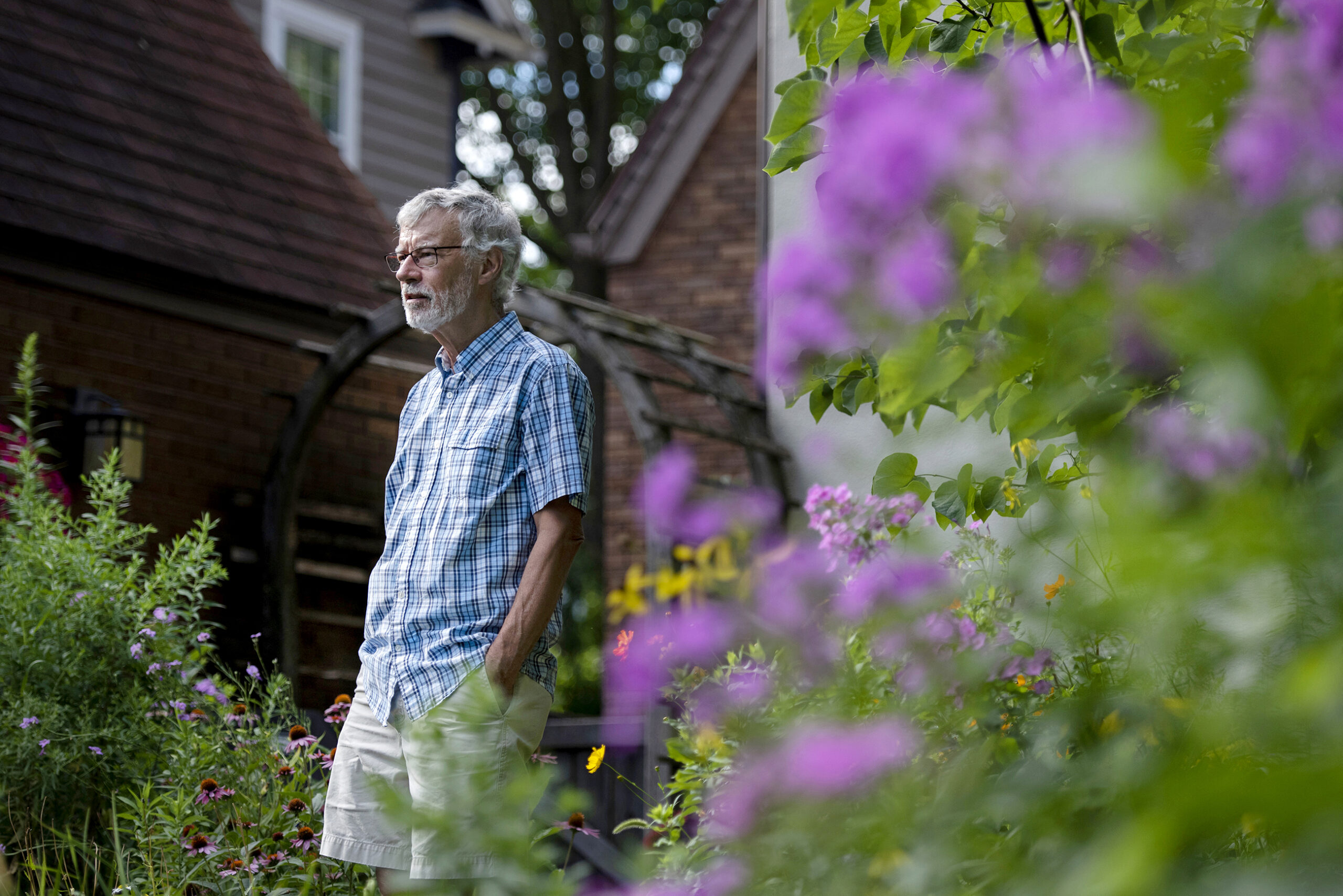 A man is surrounded by flowers in his backyard
