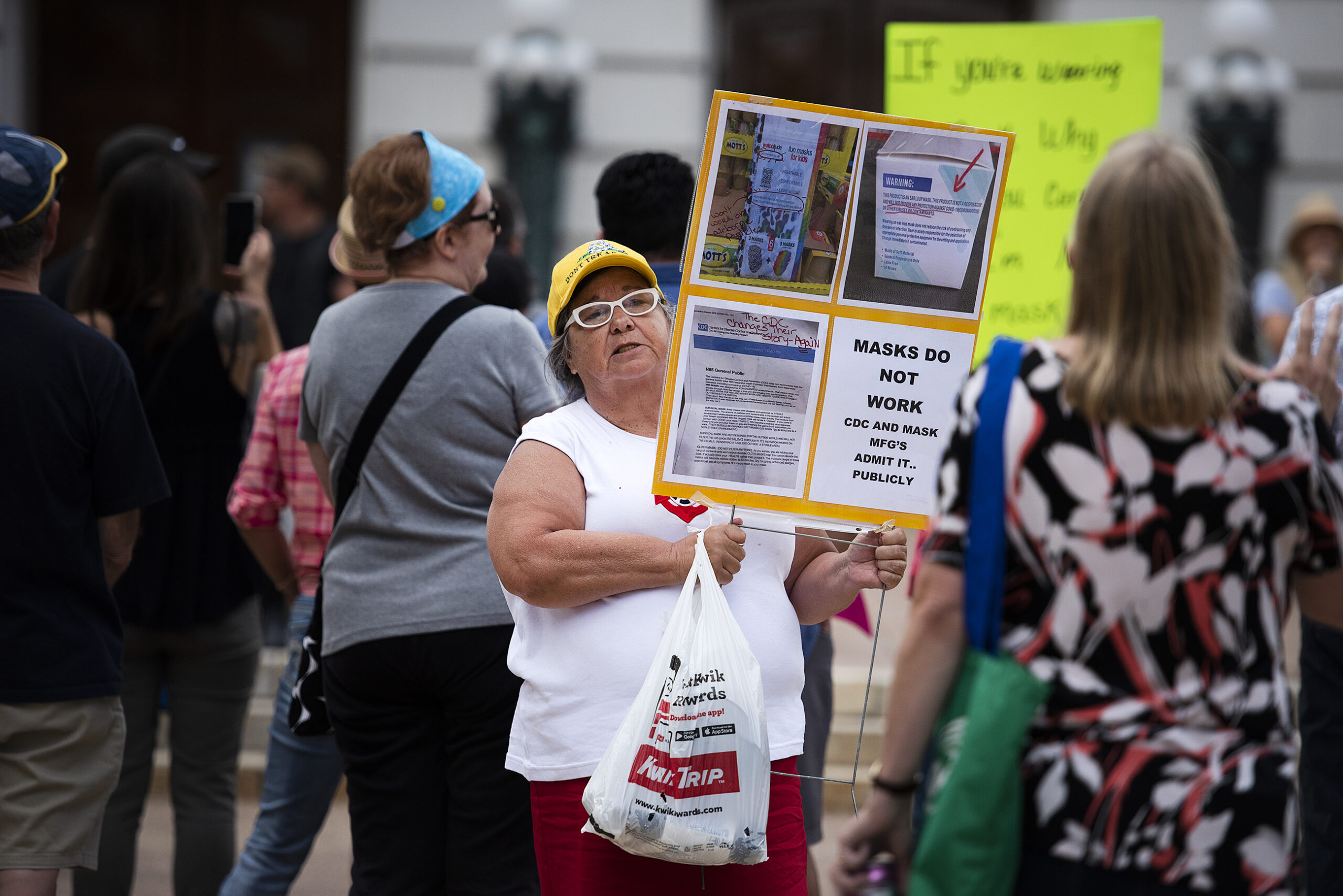 A person holds a sign at an anti-mask mandate protest