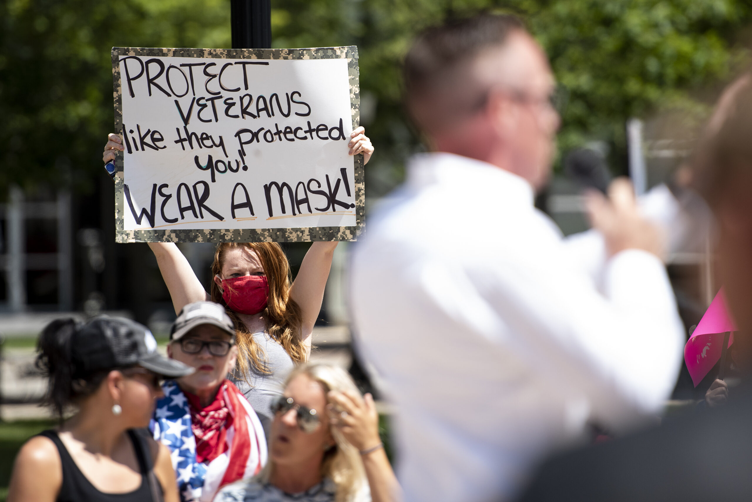 a woman holds up a sign that says 