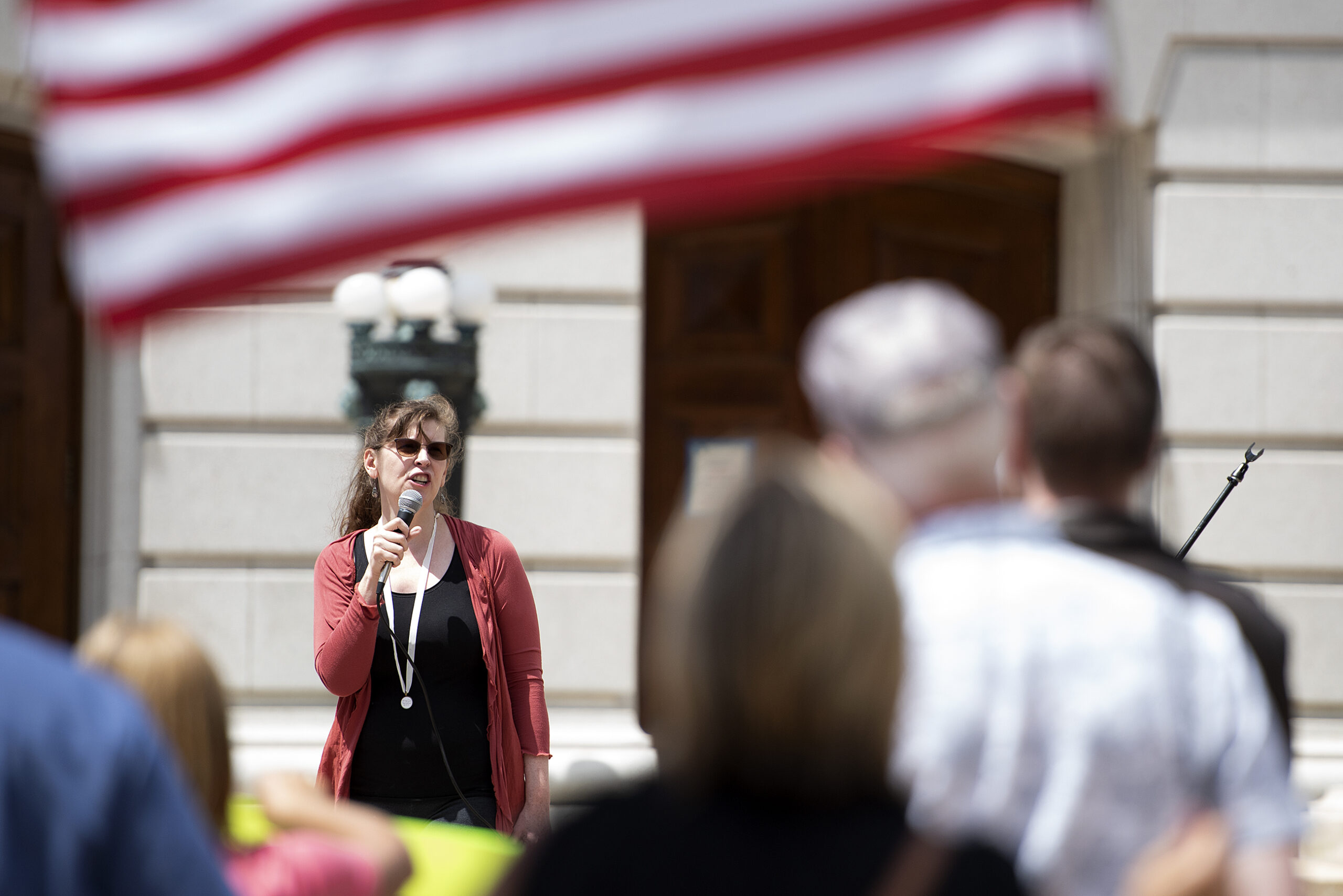 an American flag flies in the crowd as a speaker takes the microphone