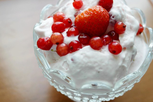 Bowl of ice cream with strawberries and currants