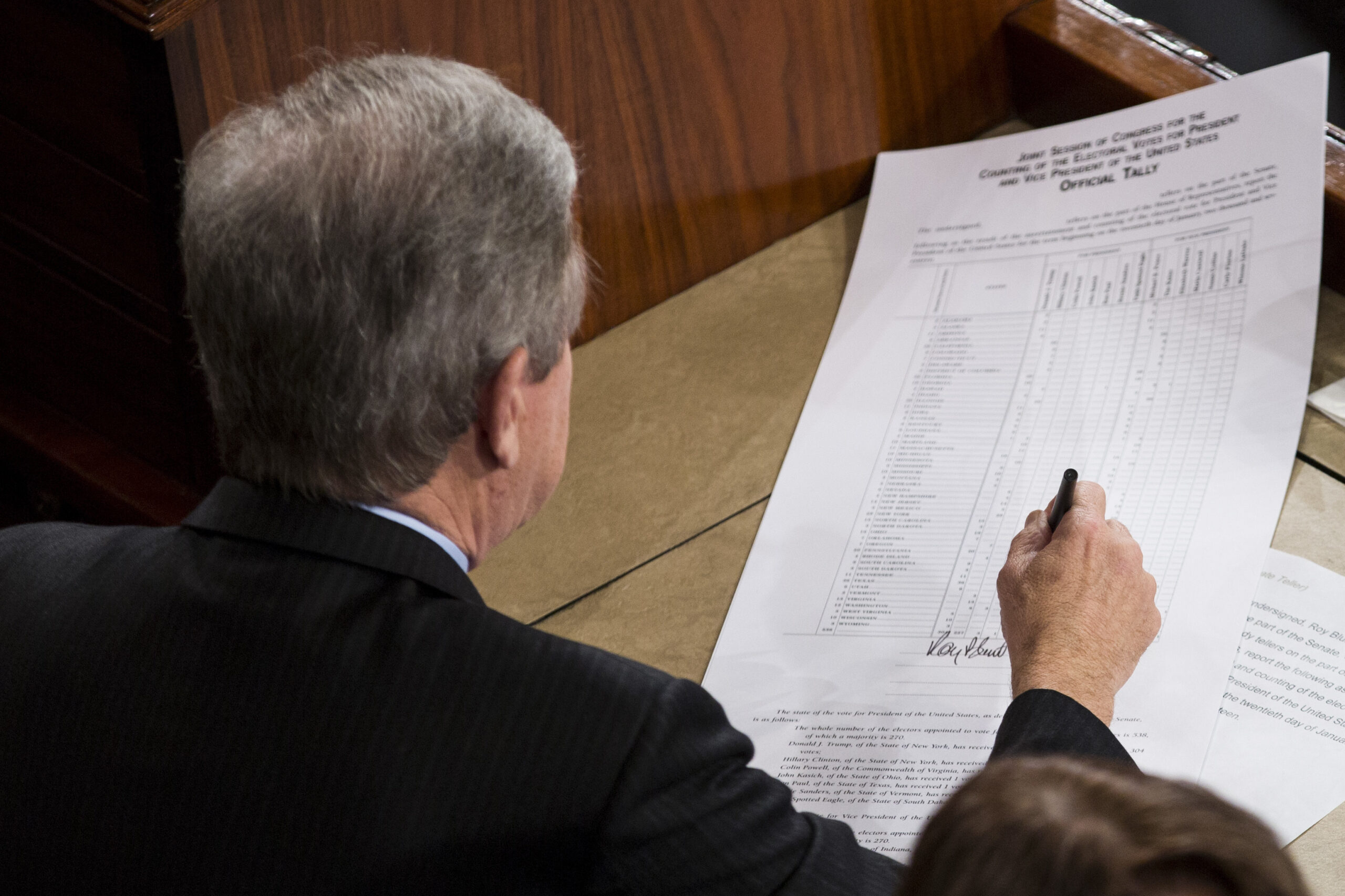 Sen. Roy Blunt, R-Mo., left, signs off on an official tally following a joint session of Congress to count Electoral College