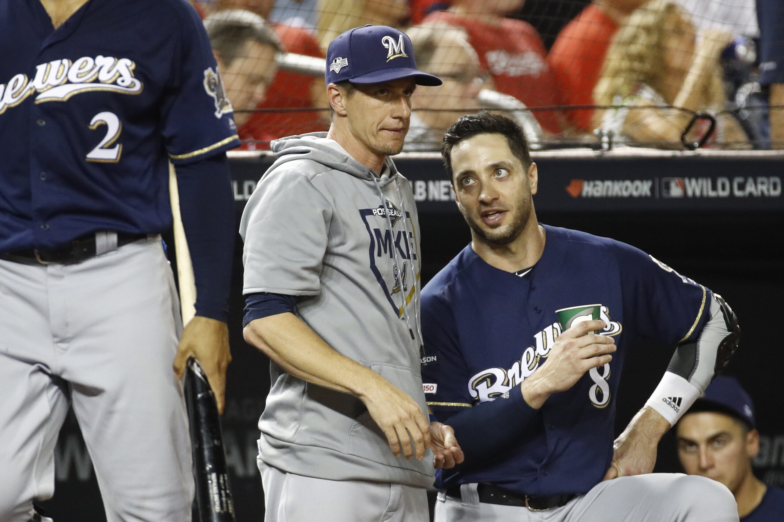 Milwaukee Brewers manager Craig Counsell, center, speaks with left fielder Ryan Braun, right