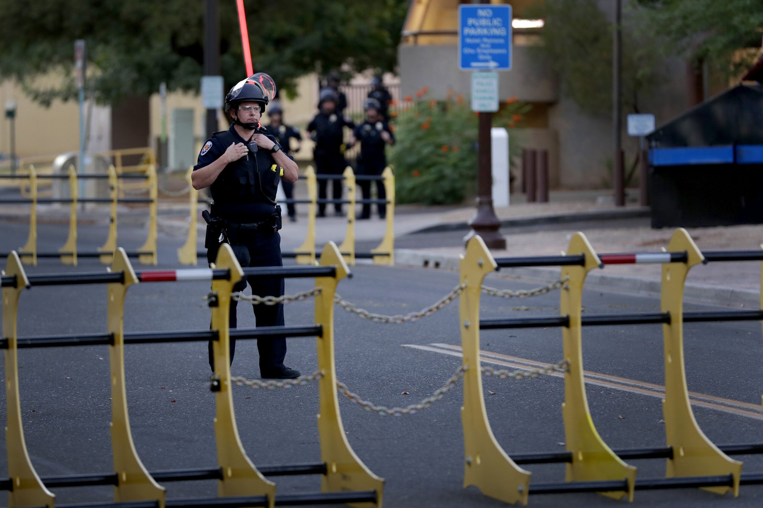 A police officer stands behind a barricade