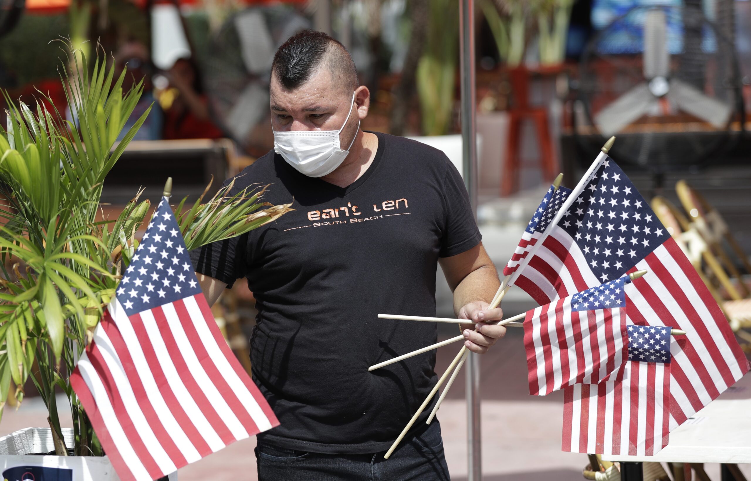 Marvin Turcios puts out American flags at Ocean's 10 restaurant on Miami Beach, Florida