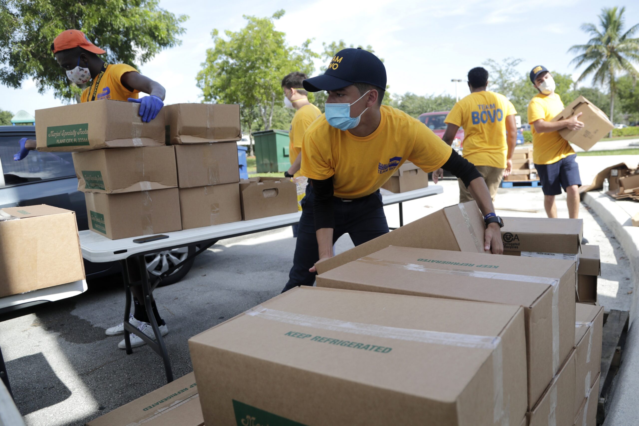 Nicholas Martinez stacks boxes of produce at a free drive-through food distribution in Florida.