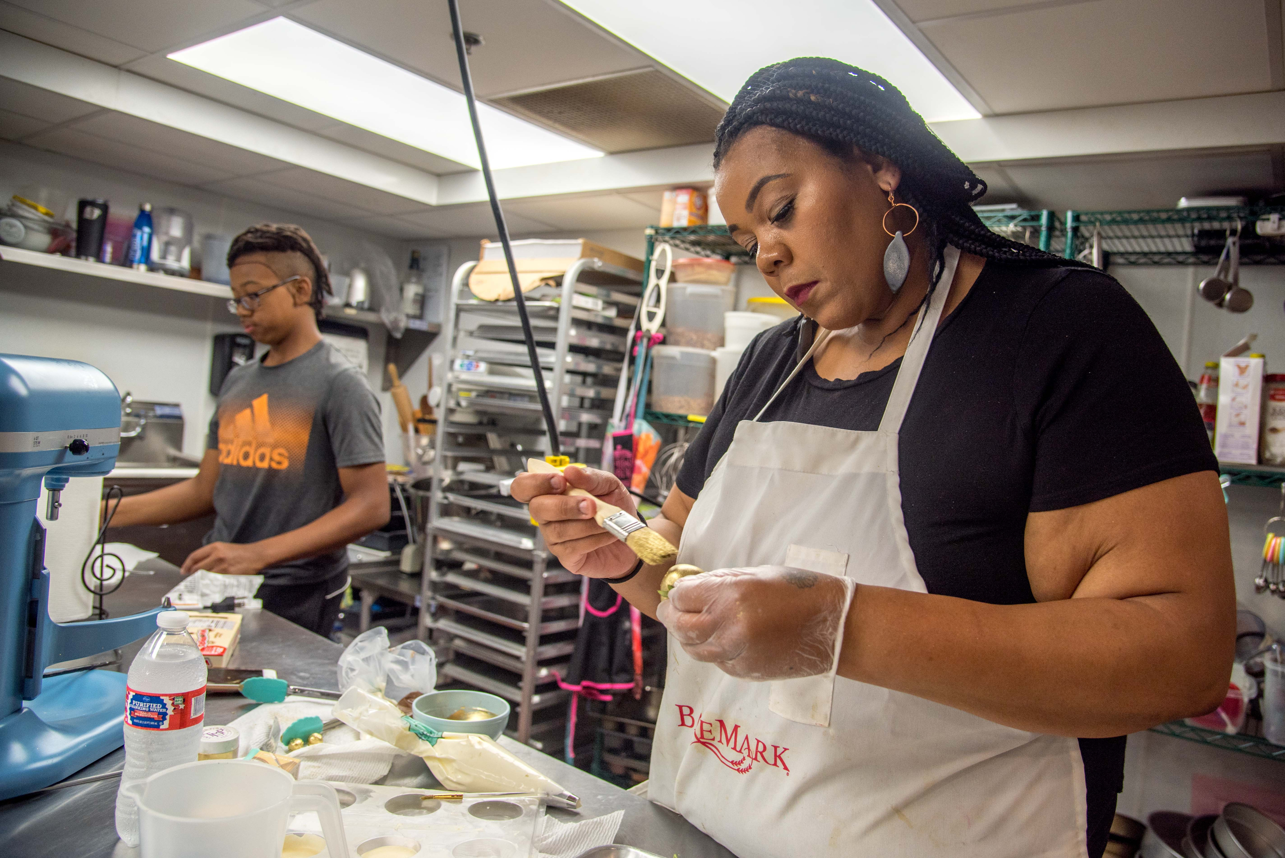 Adija Greer-Smith, right, decorates strawberries as her son Xavier Smith helps.