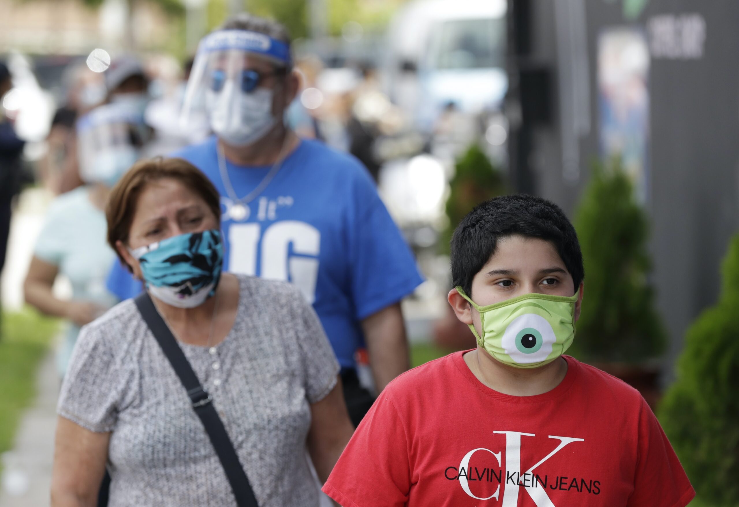 People waiting in line wearing masks