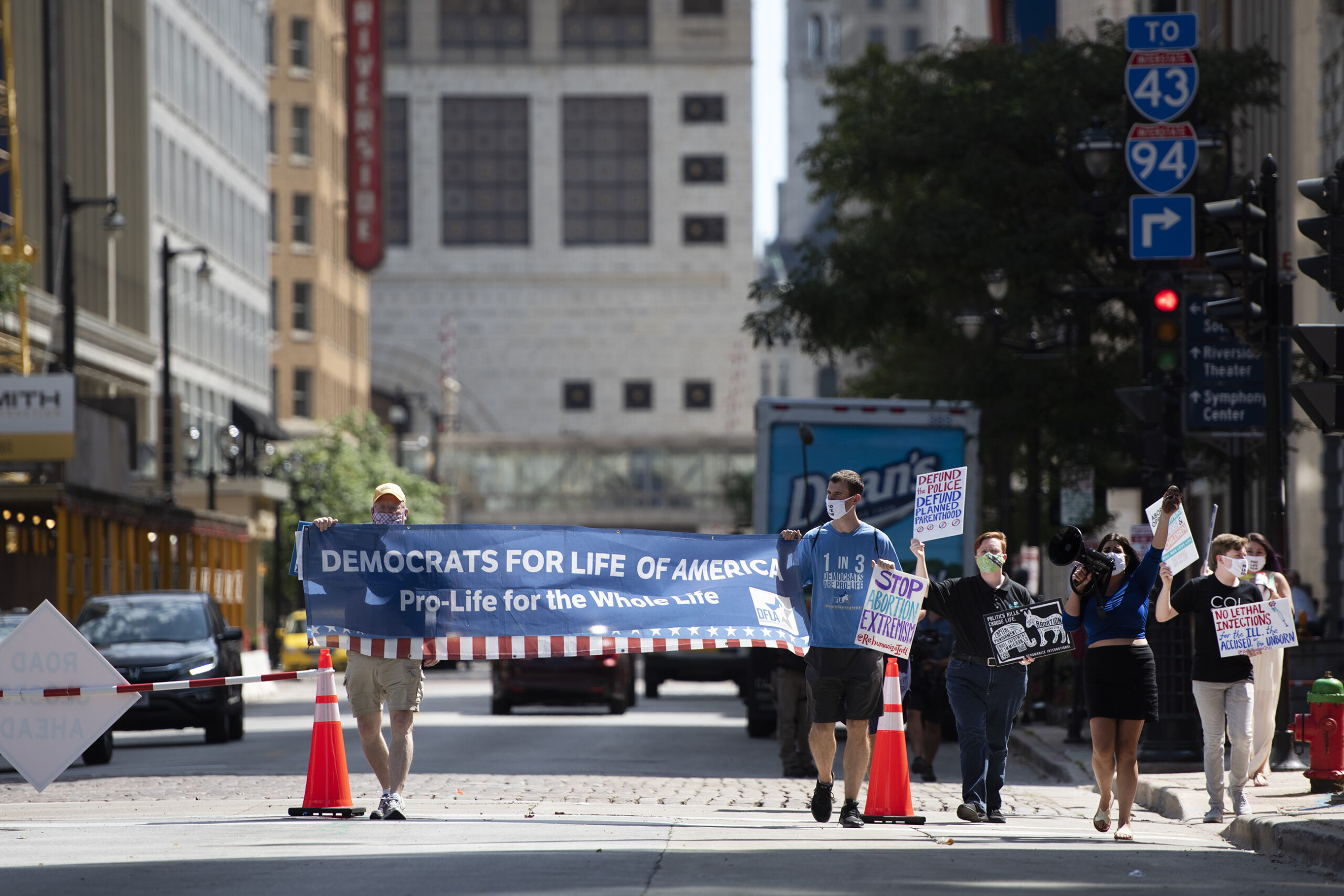 protesters hold a banner as they march down the street