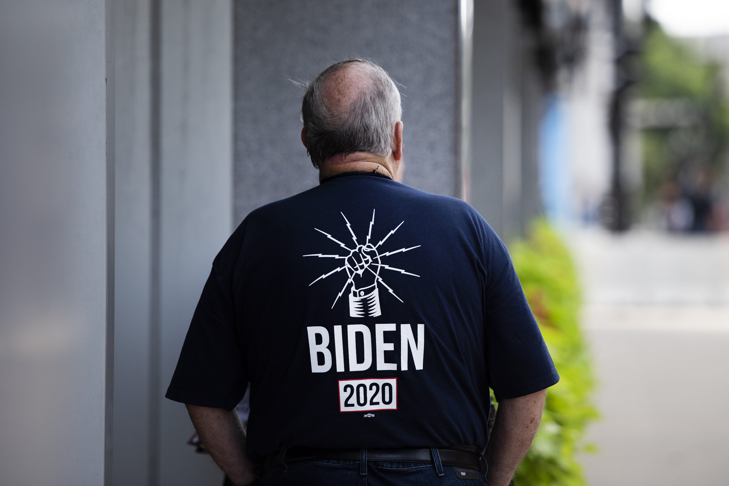 a man seen from behind has a shirt that says 
