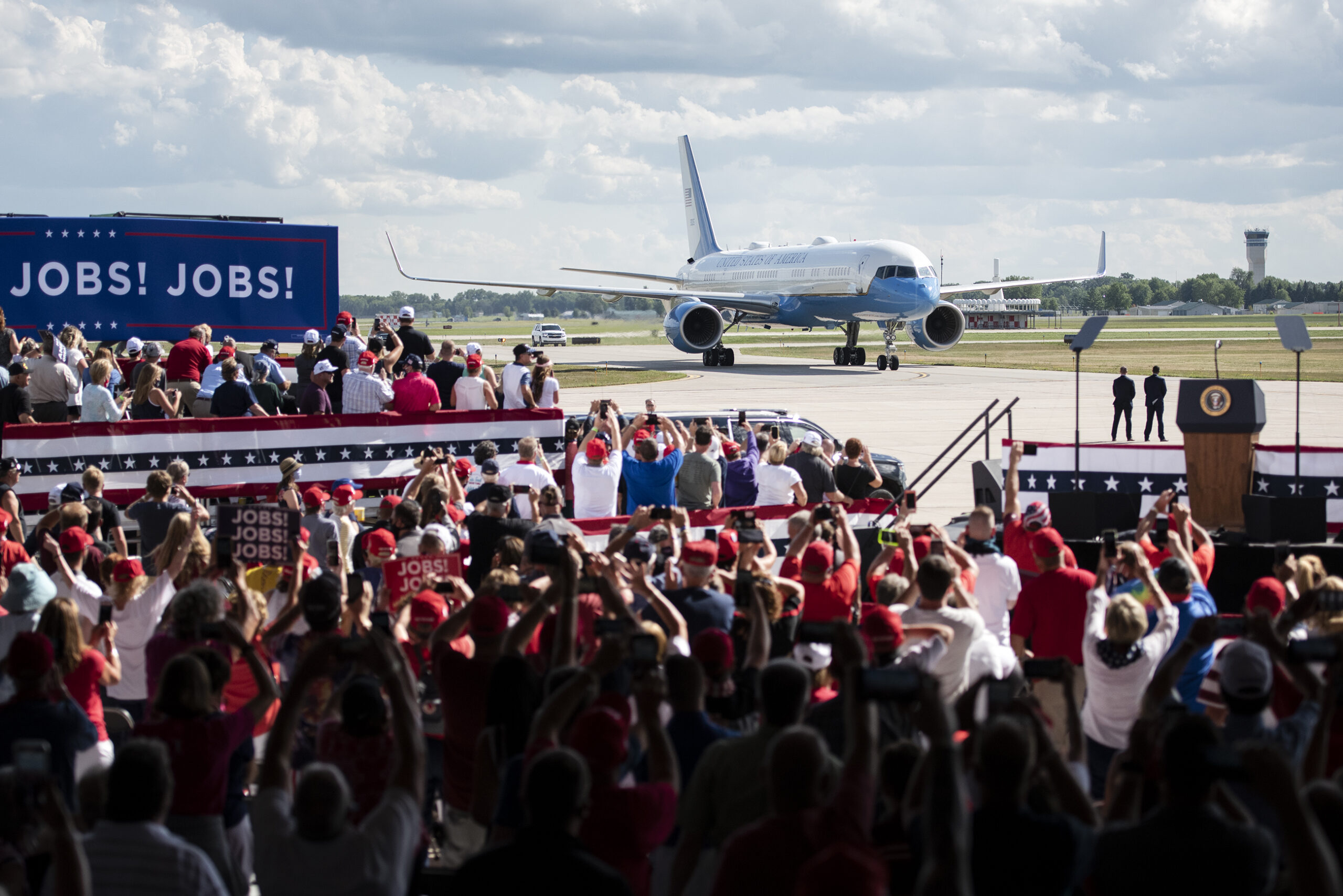 the crowd cheers as Air Force one drives up on the runway