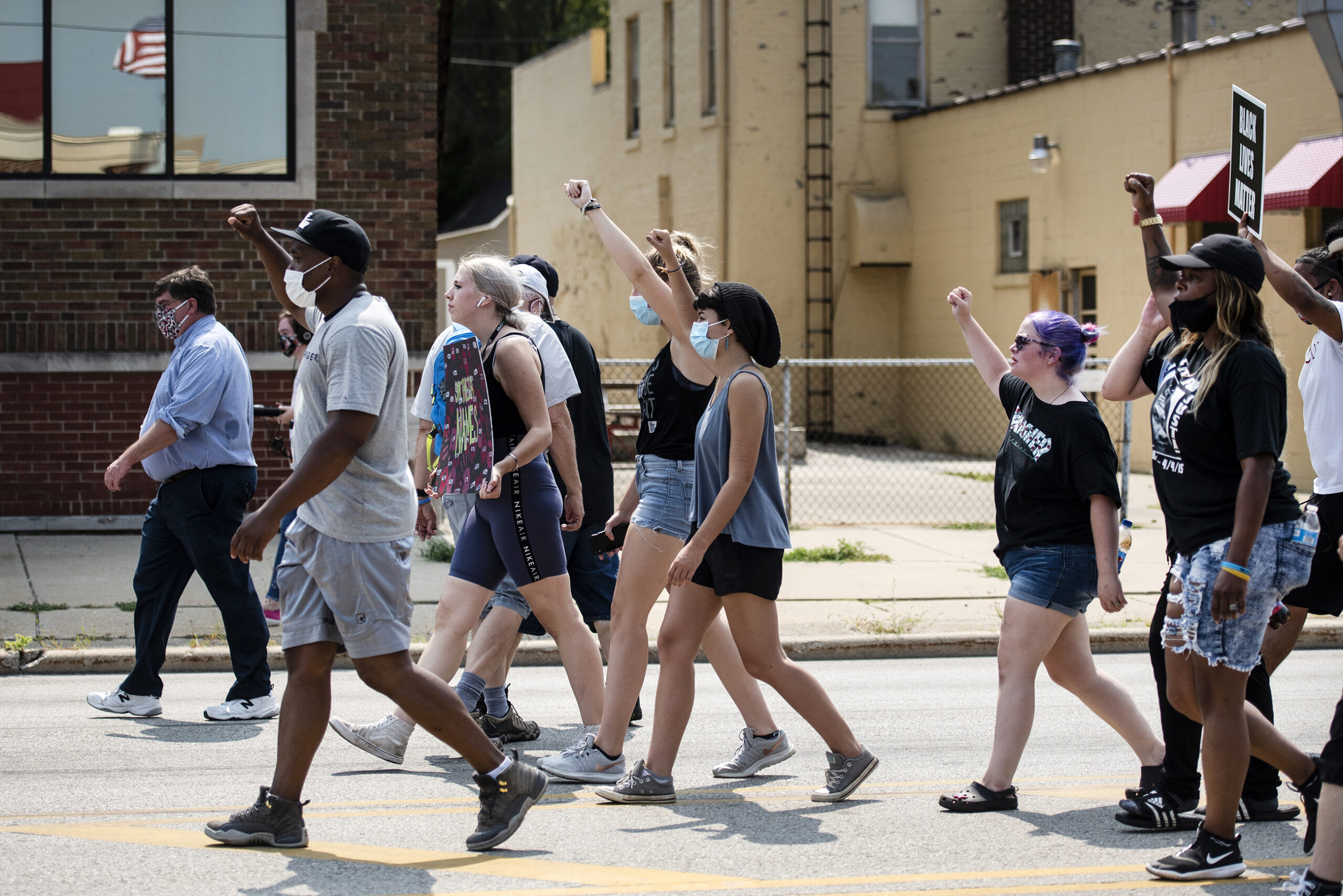 A group of protesters raise their fists as they march in the street