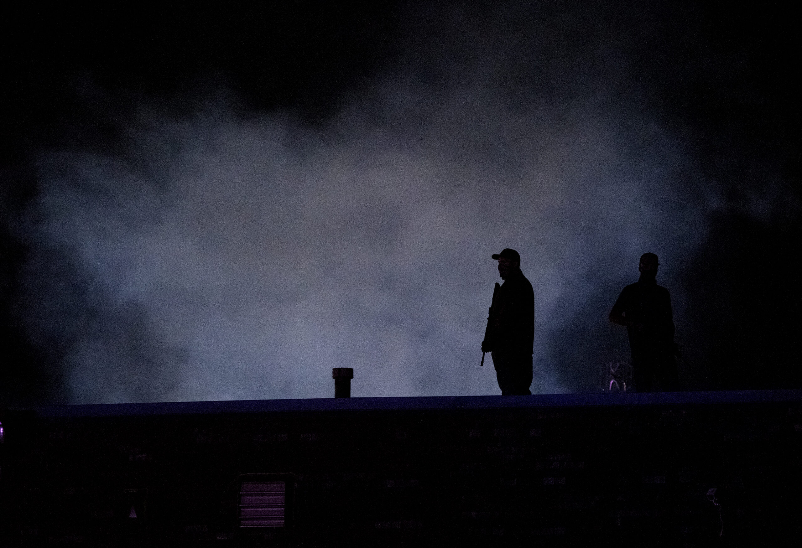 a man is seen in silhouette holding what appears to be a gun