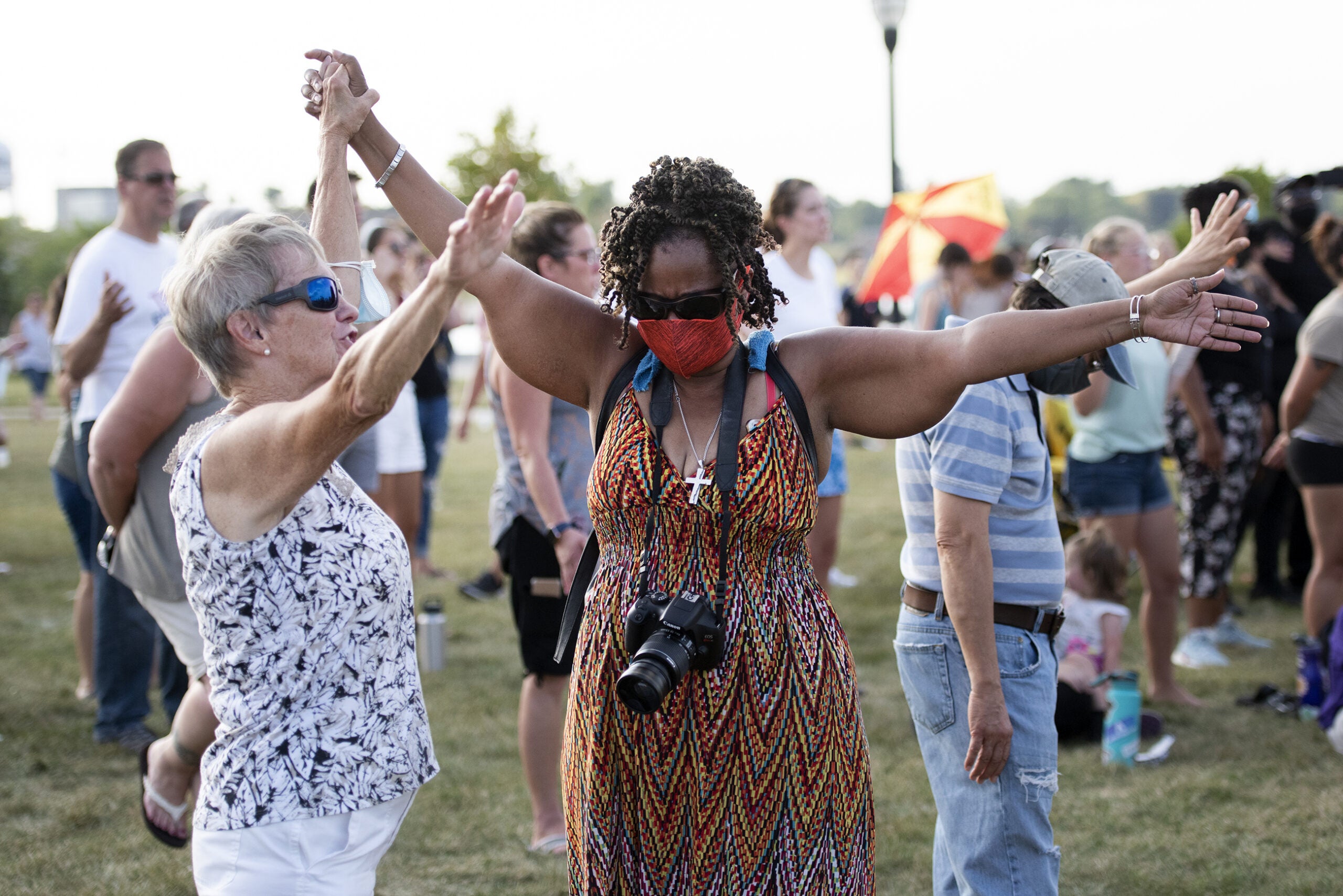 two women spread their arms out and sway as a song plays