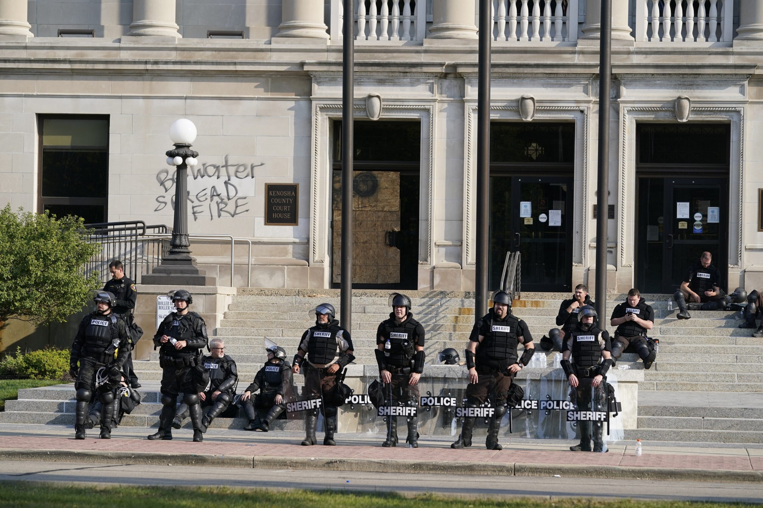Police in riot gear stand outside the Kenosha County Court House