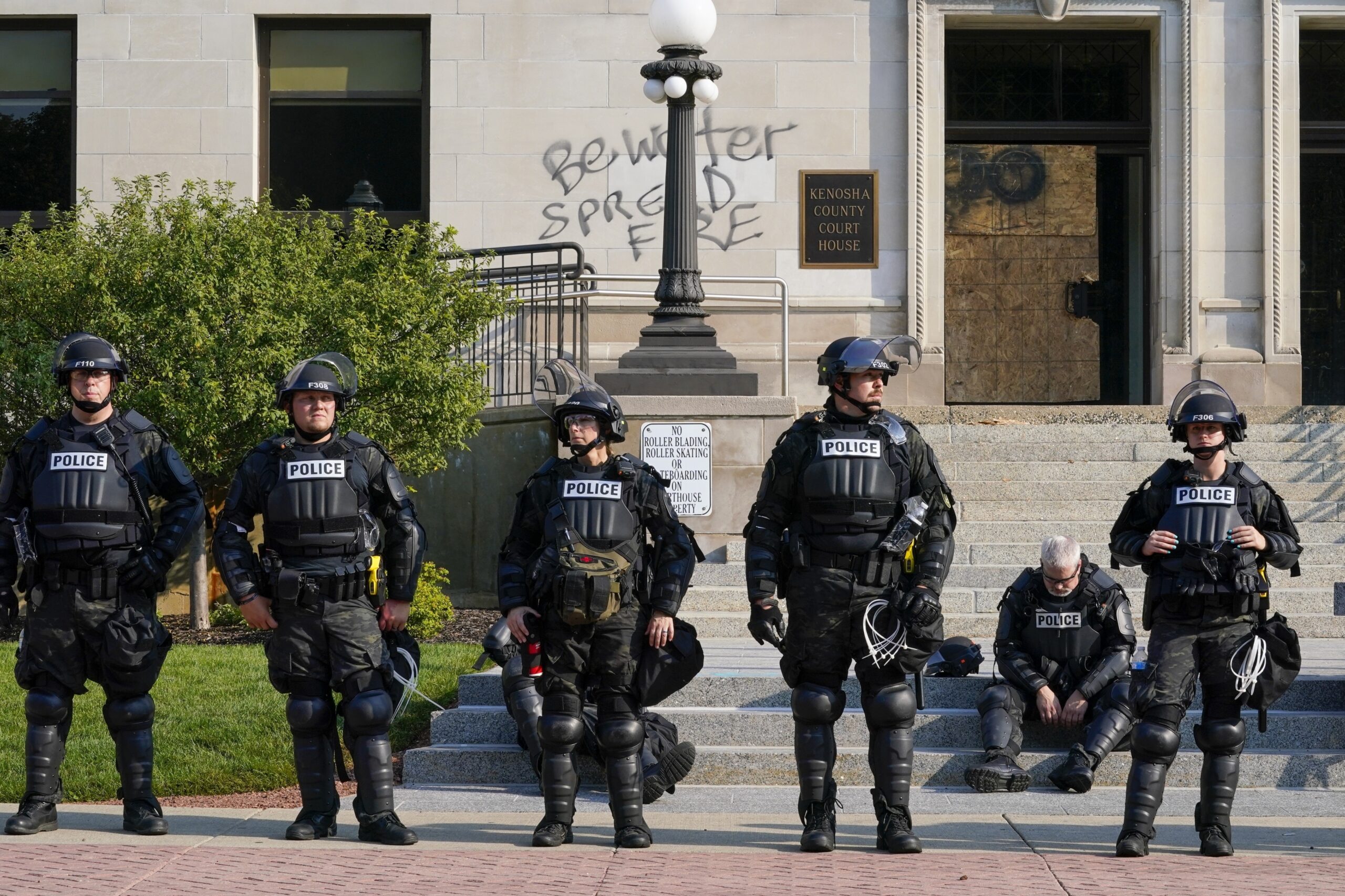 Police in riot gear stand outside the Kenosha County Court House