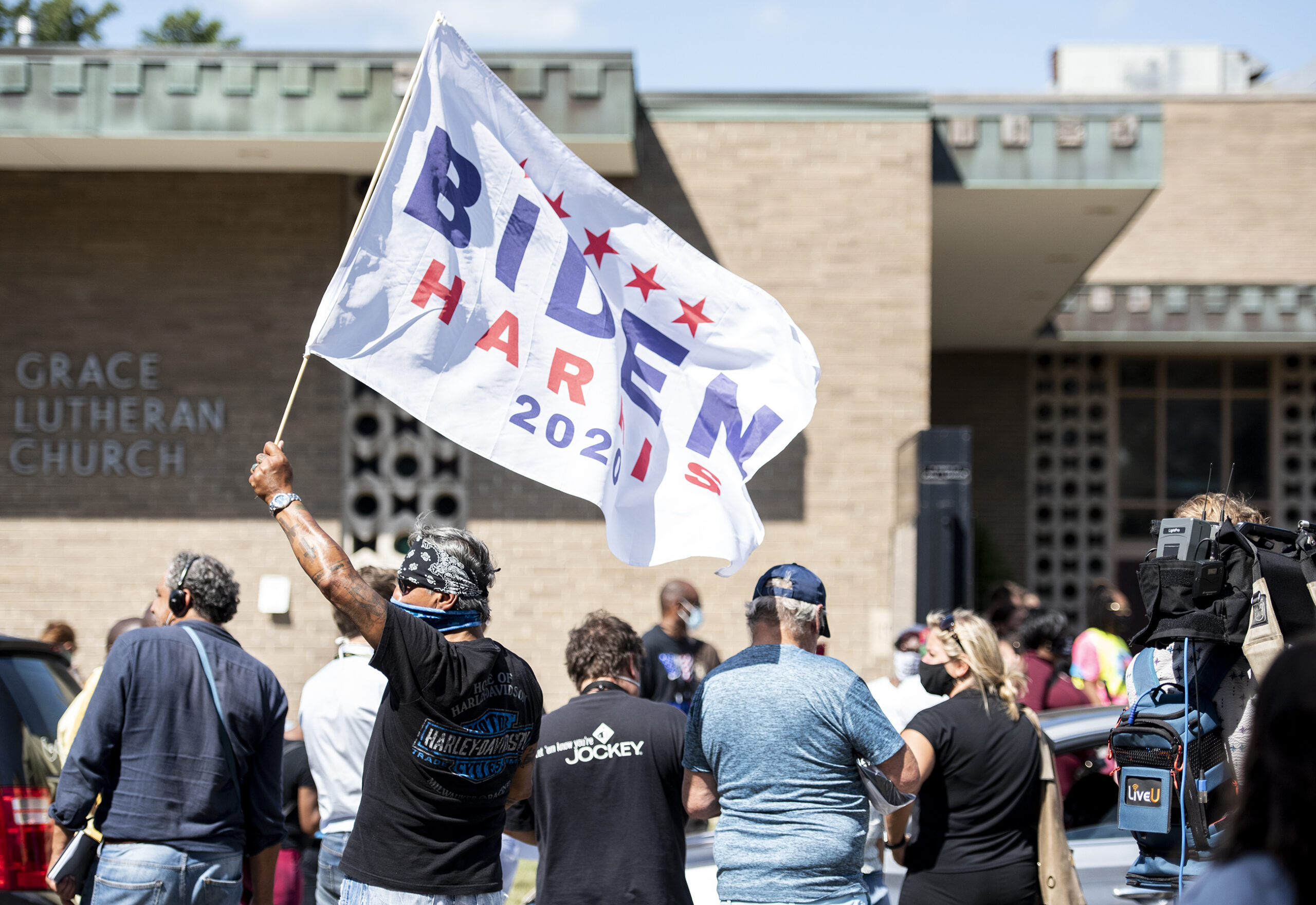 A man has a red white and blue flag that says 