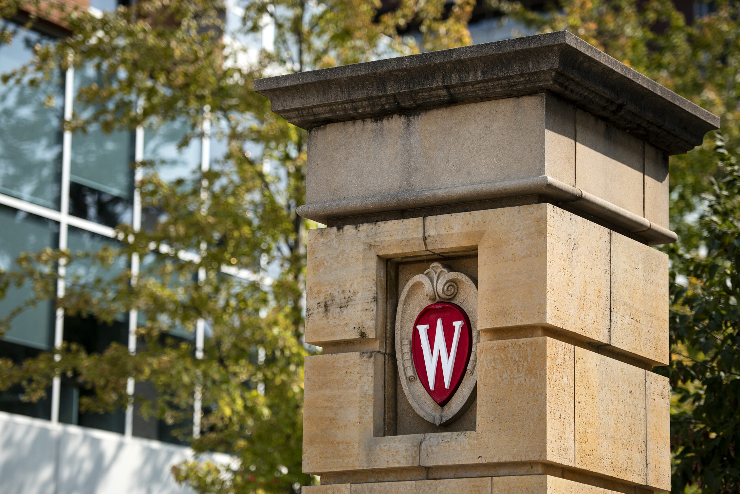 A red "W" logo is seen on a column on UW-Madison's campus