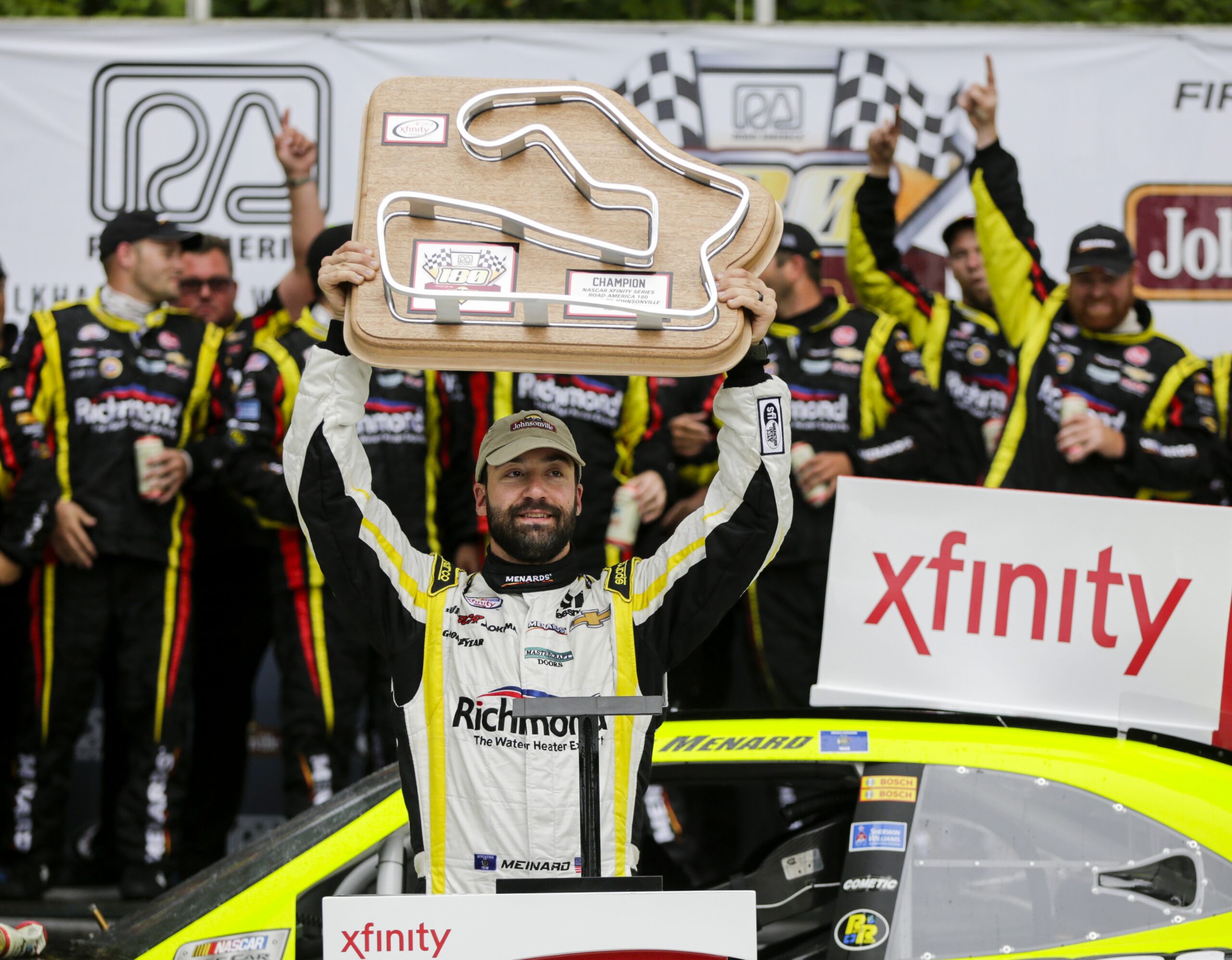 Paul Menard holds up the trophy after wining the NASCAR Xfinity Series auto race at Road America