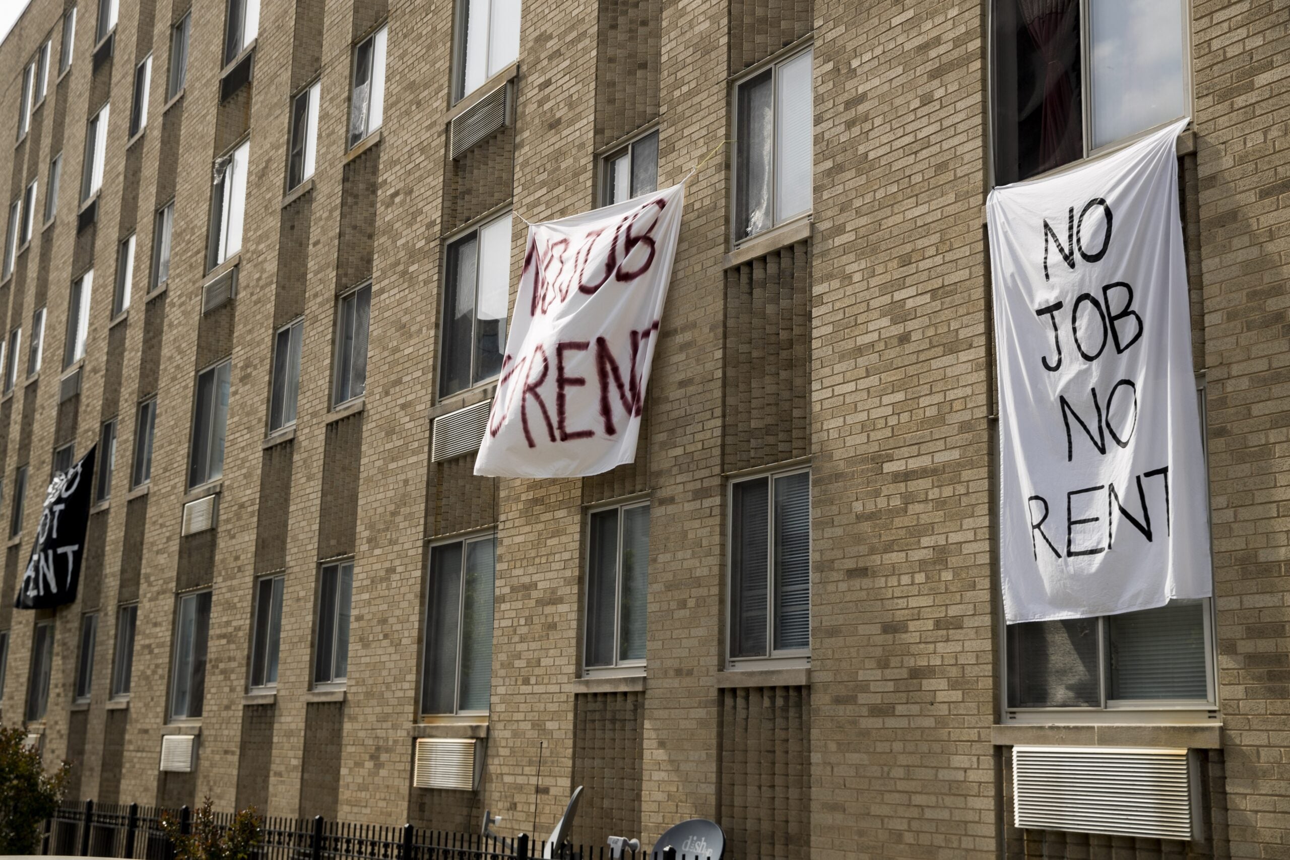 Signs reading "No Job No Rent"