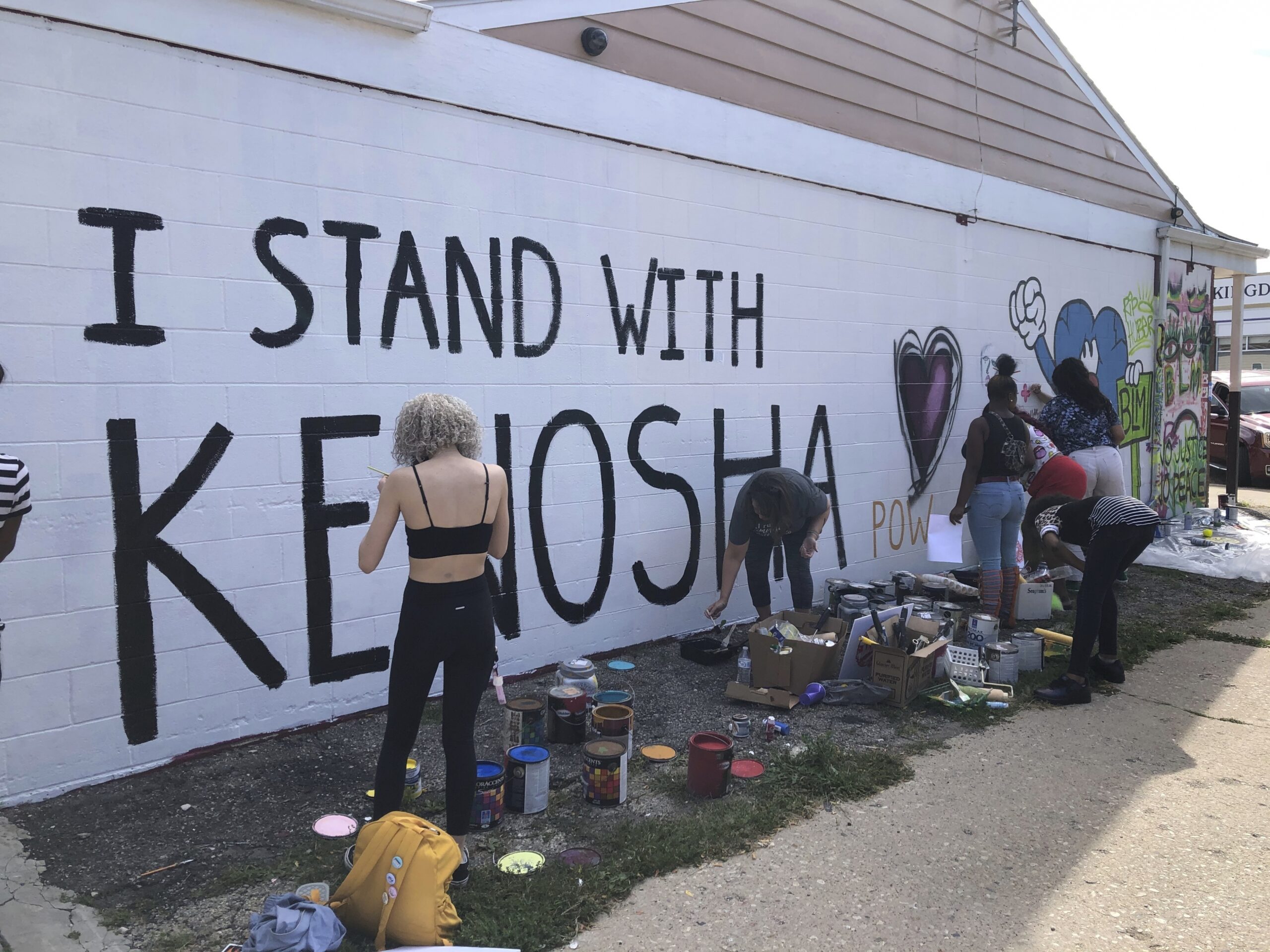 Volunteers paint murals on boarded-up businesses in Kenosha