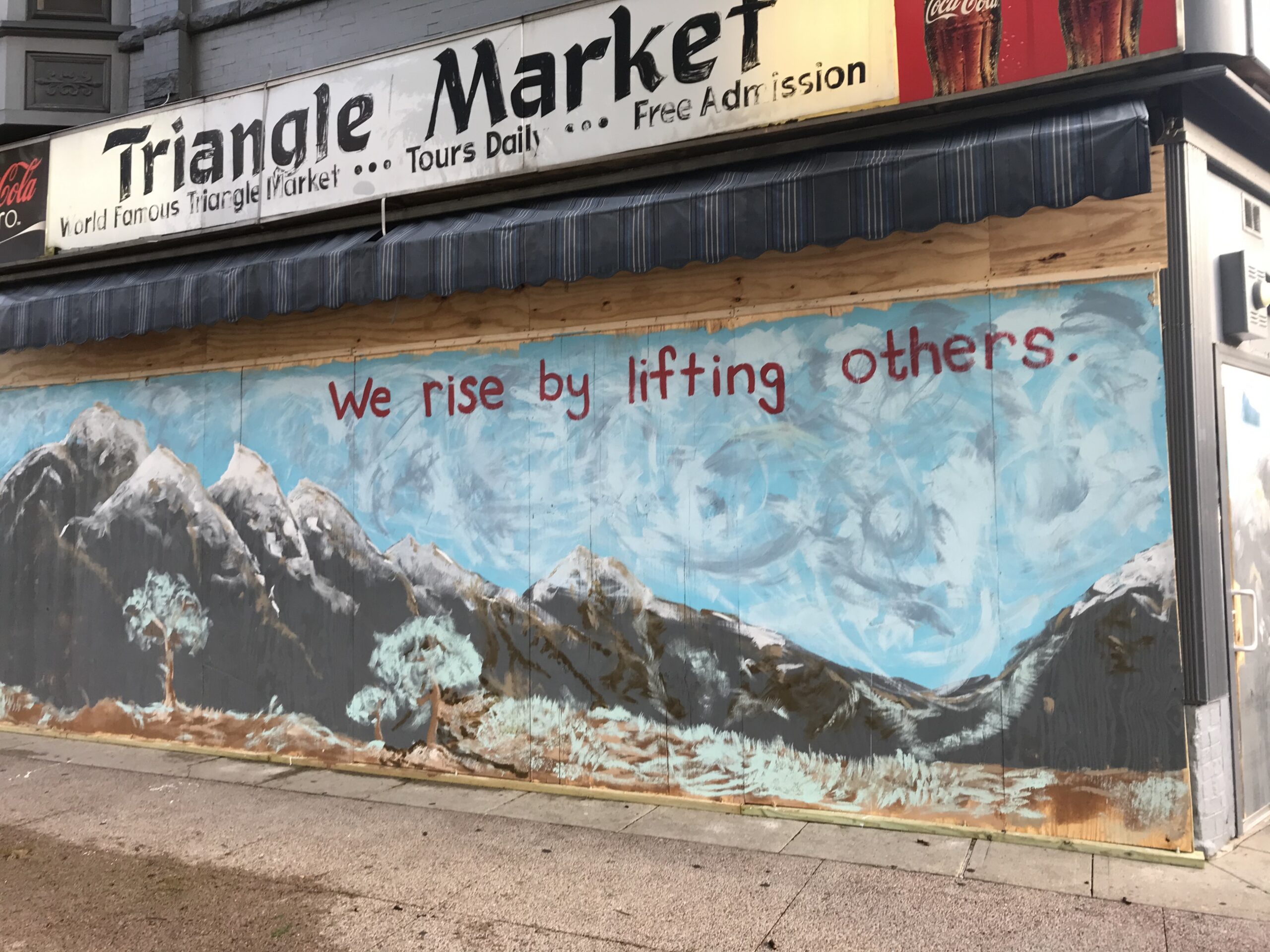 Hopeful messages and artistic creativity stand a stark contrast to broken, boarded-up windows