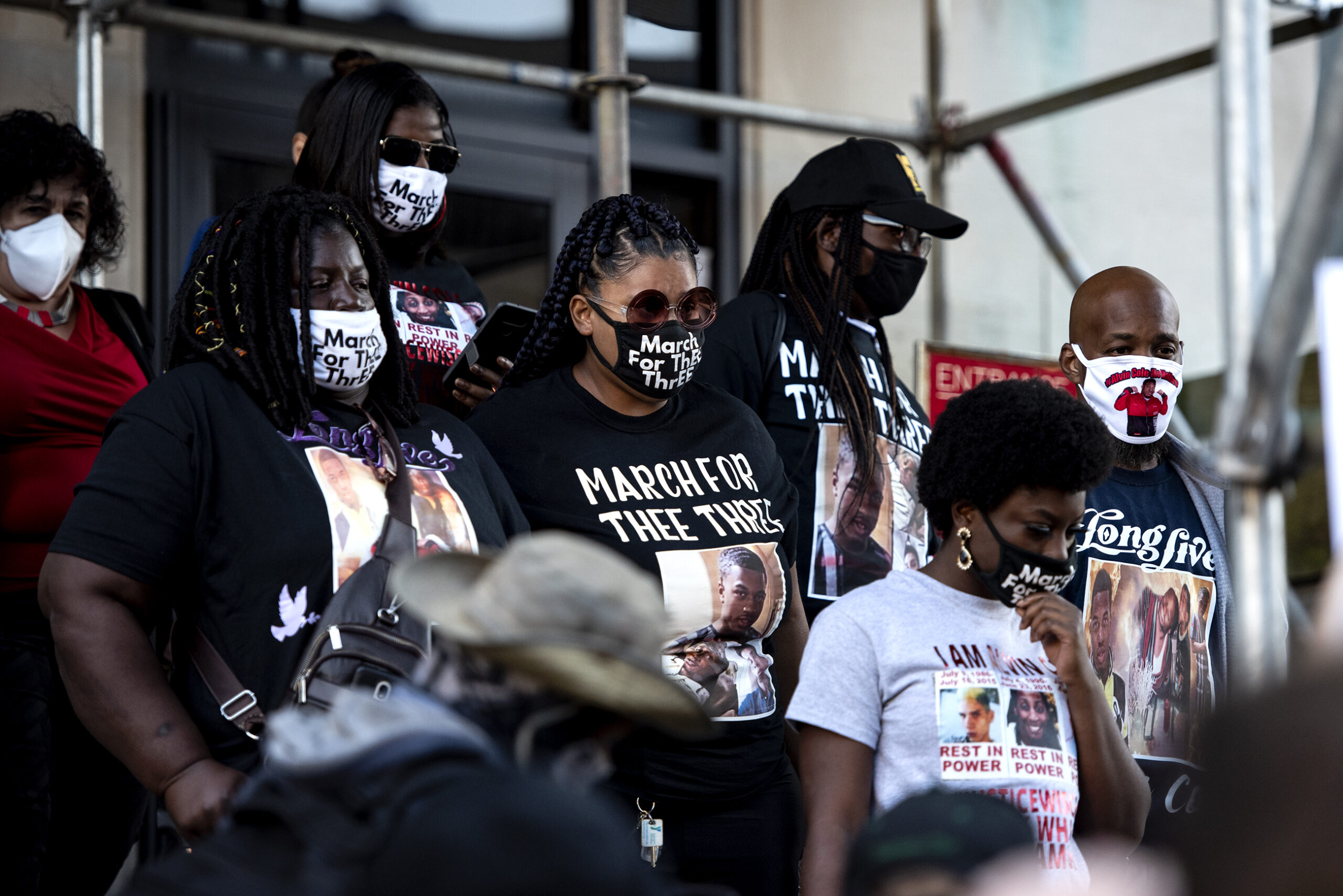 Alvin Cole's family members wear masks as they walk down the stairs toward the protesters