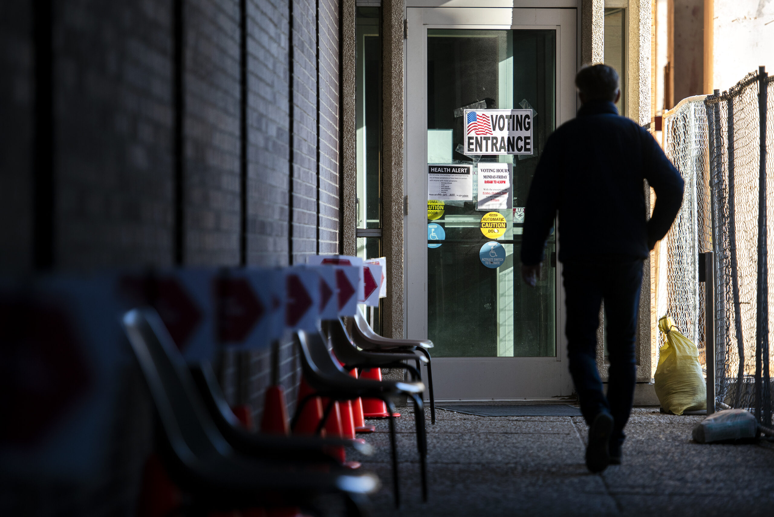 A voter in silhouette walks toward a door that says "Voting Entrance"