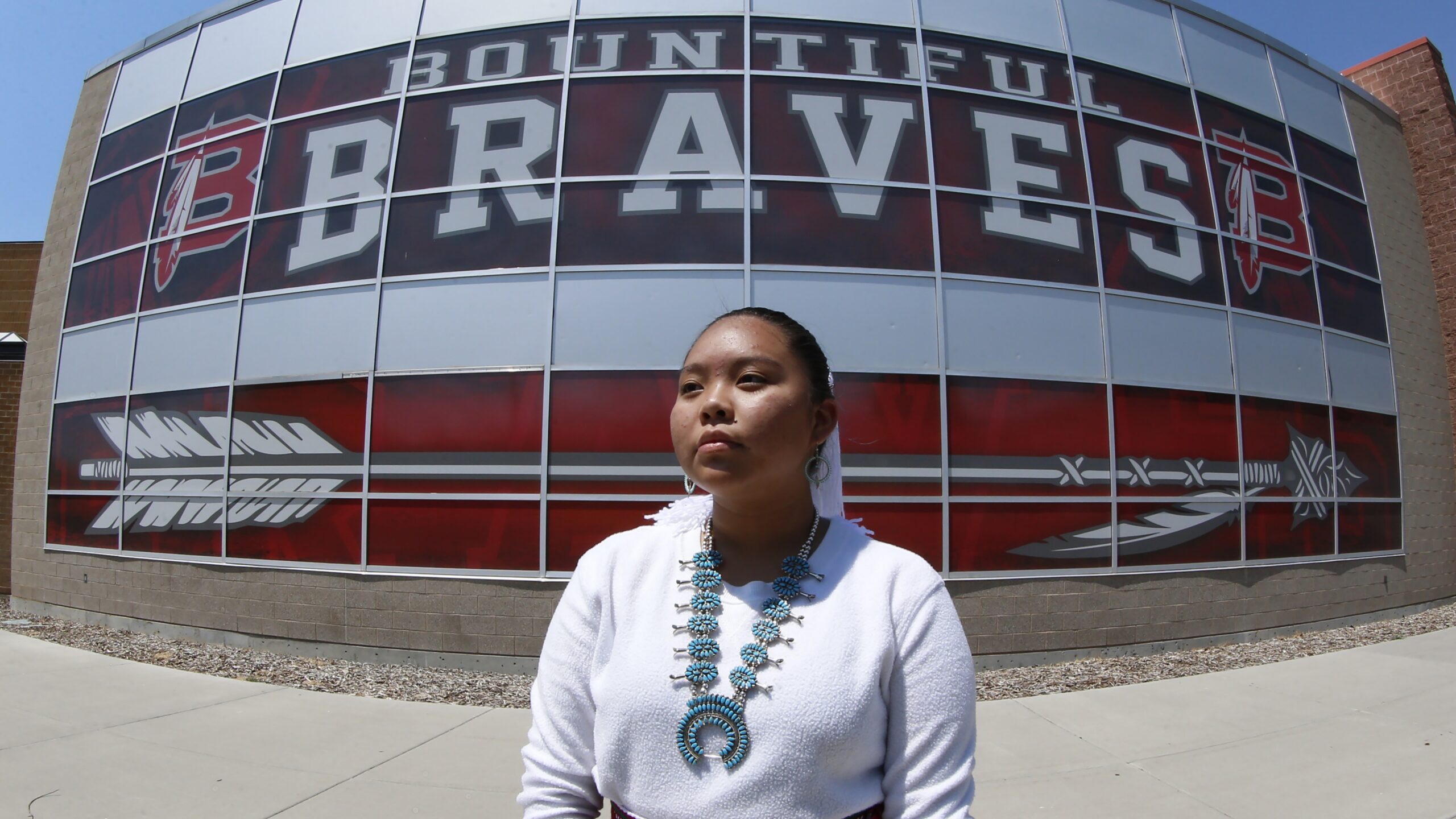 A Navajo student in front of her high school